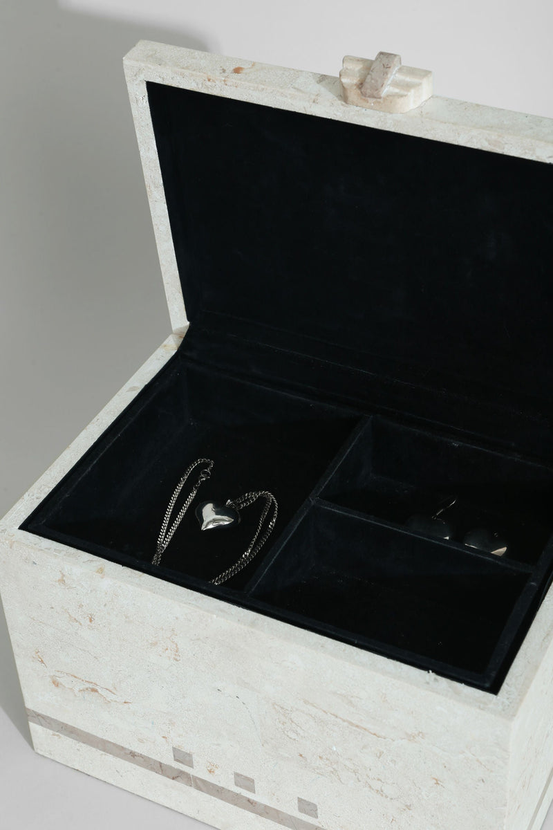 Open tessellated stone jewelry box showing black velvet compartments