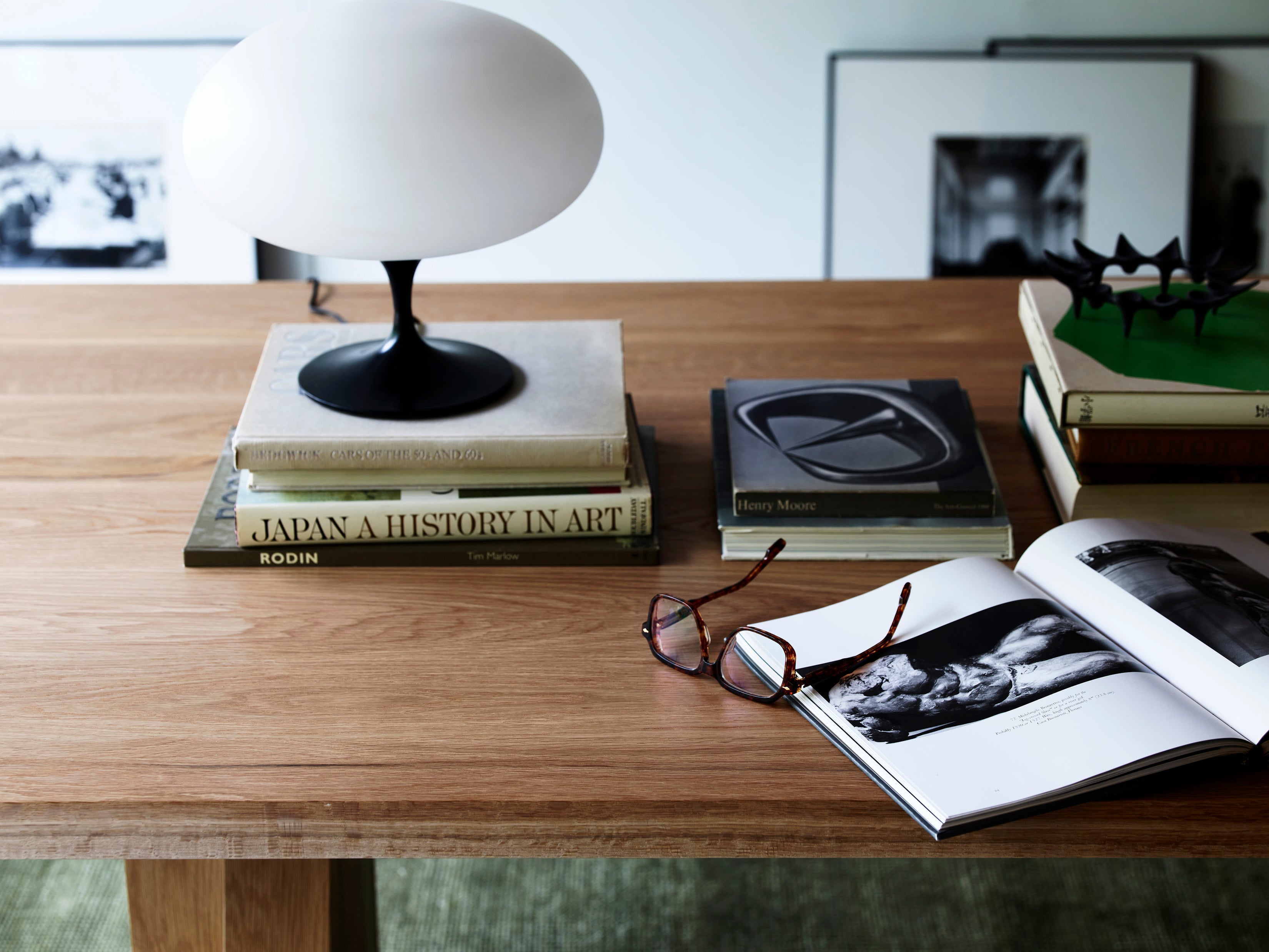 Elmyr Dining Table — top view with oak surface and books