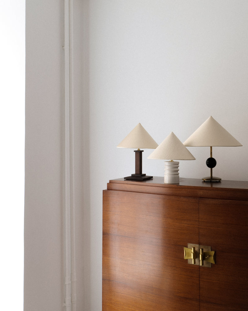 Three conical shade table lamps styled on walnut credenza with brass hardware