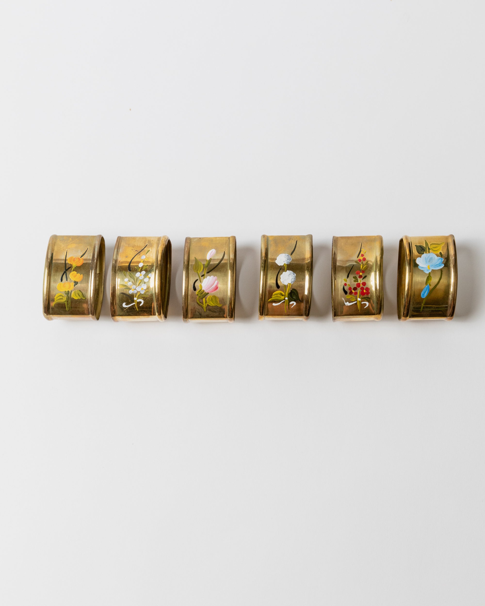 Six brass napkin rings with hand-painted floral motifs, Italy 1940s