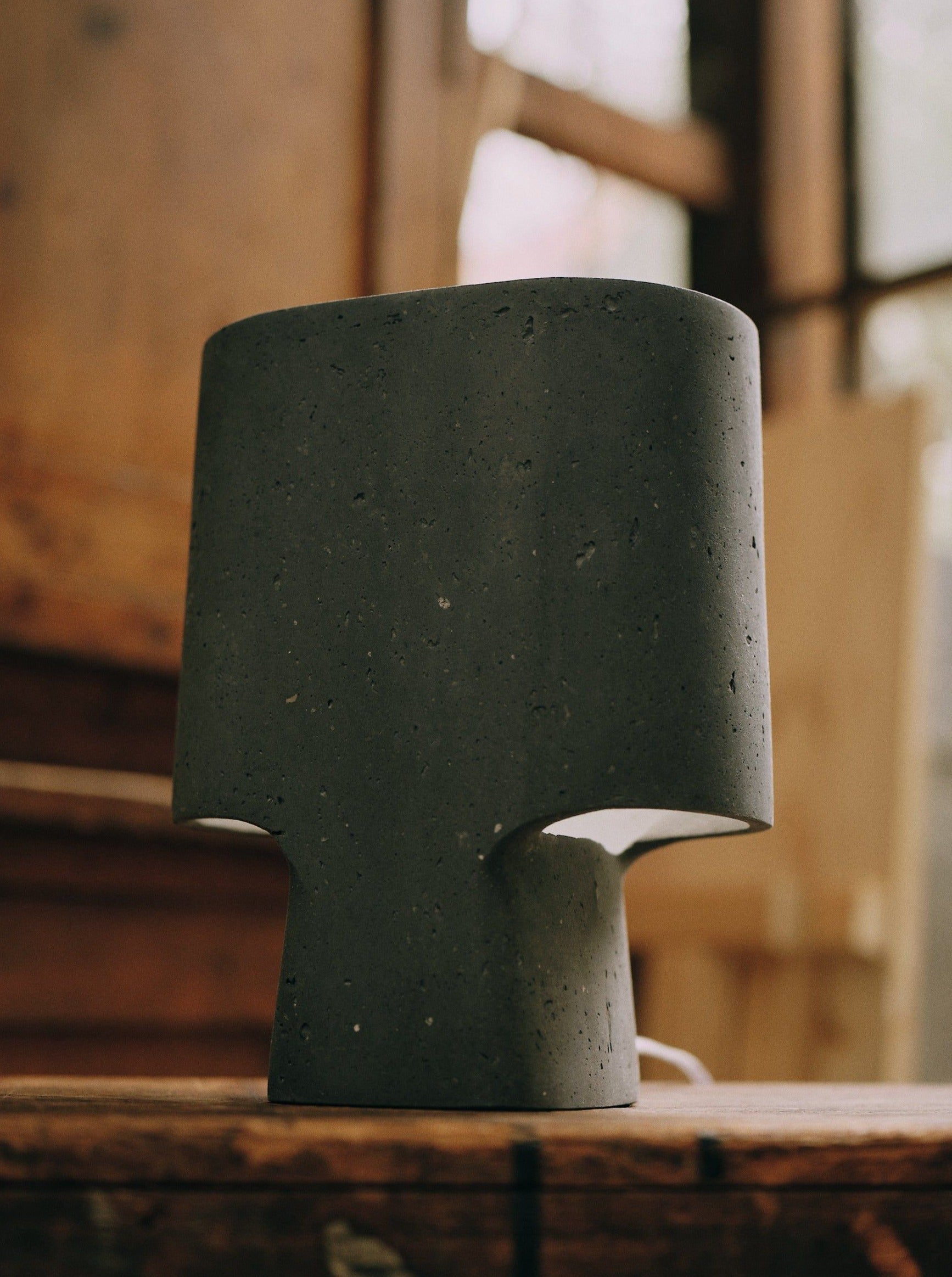 The Lamp Bien Faite Anthracite — close-up of concrete lamp on wooden table