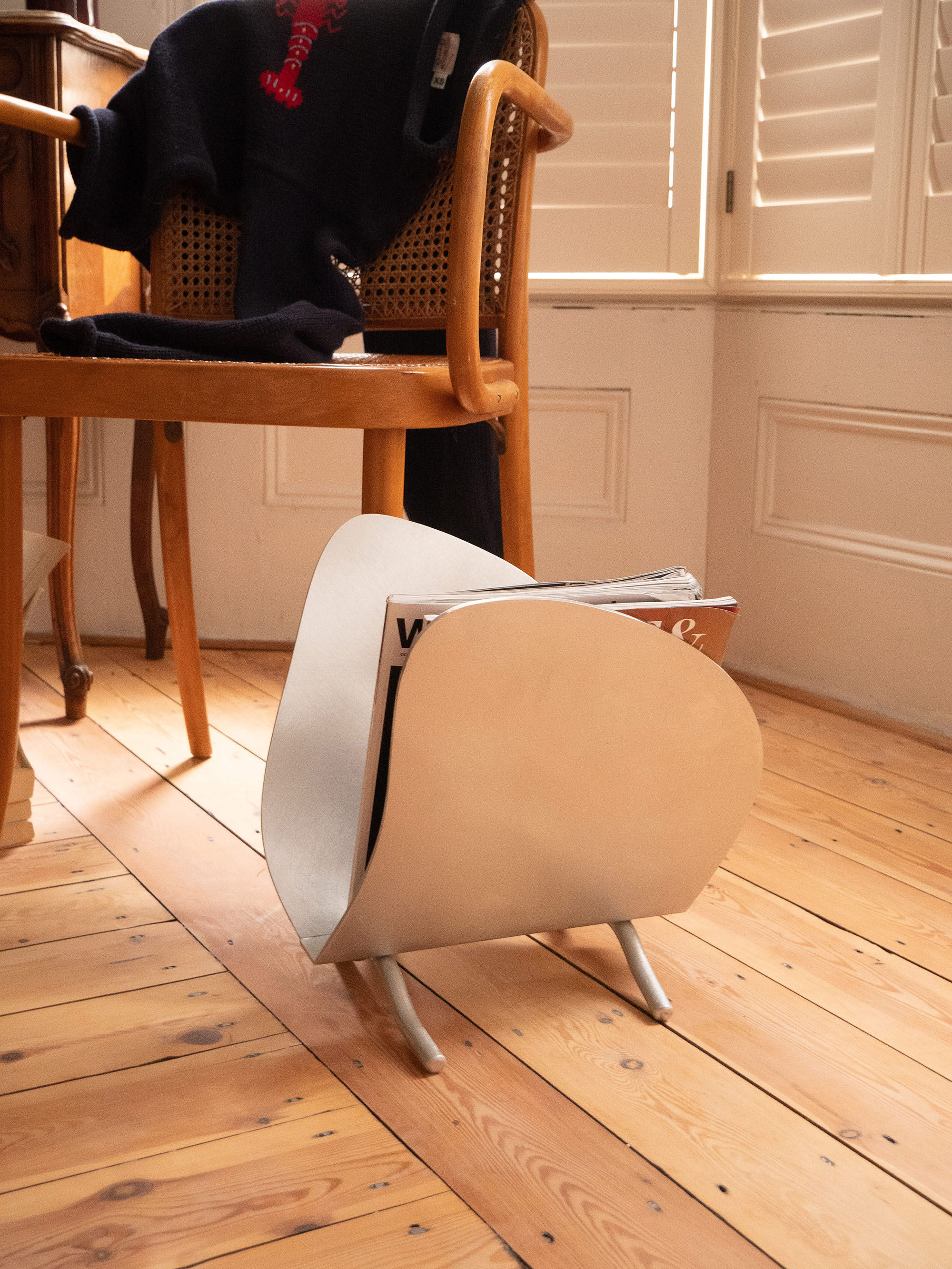 Magazine Rack — side view on wooden floor with magazines inside
