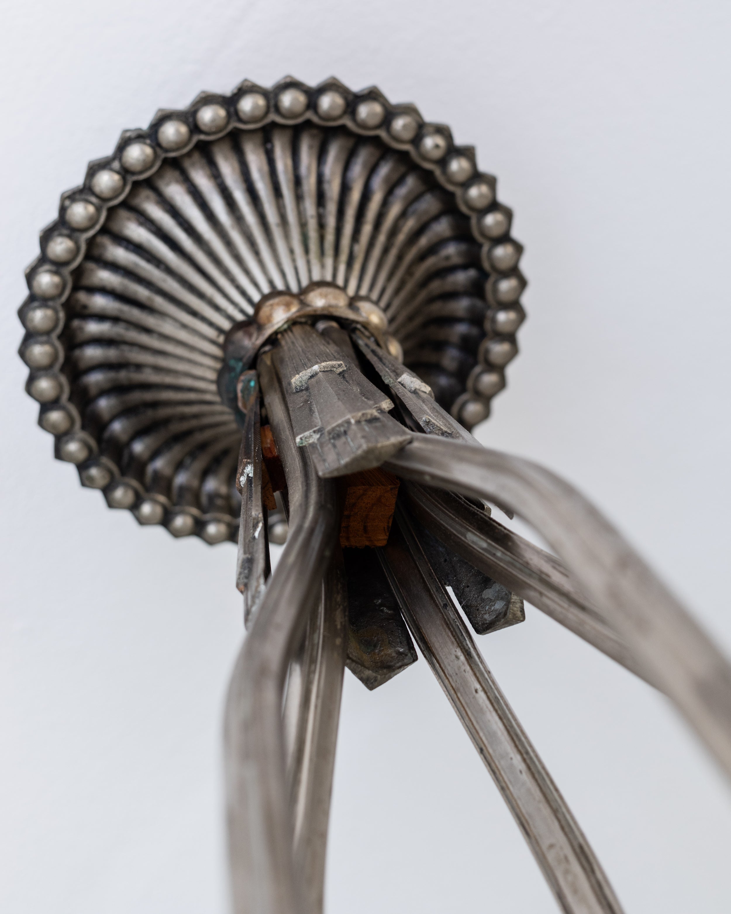 Close-up detail of Art Deco chandelier's ornate metal rosette and chain links