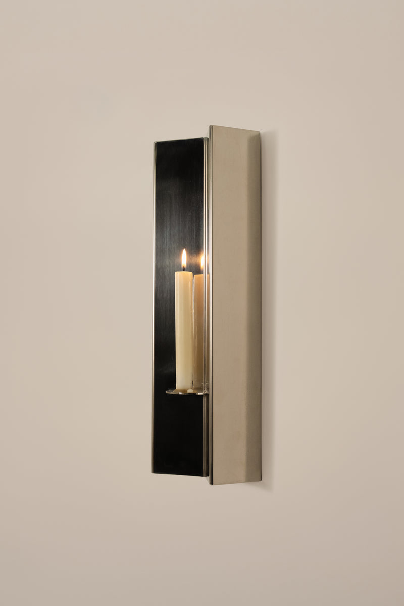 Arrow Candle Holder — close-up of polished metal with candle lit
