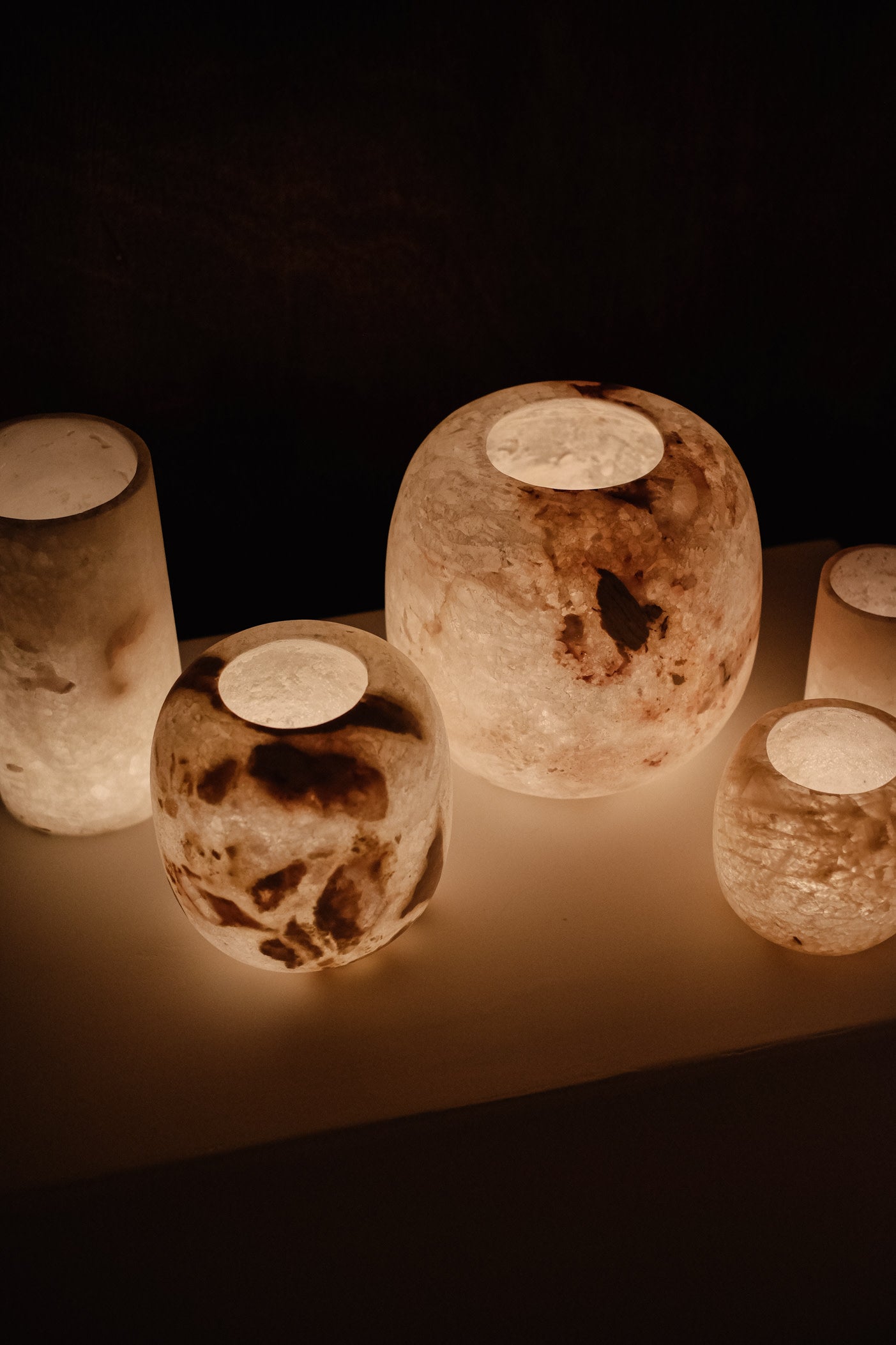 Alabaster Candle Holder — grouped on a dark surface with warm glow