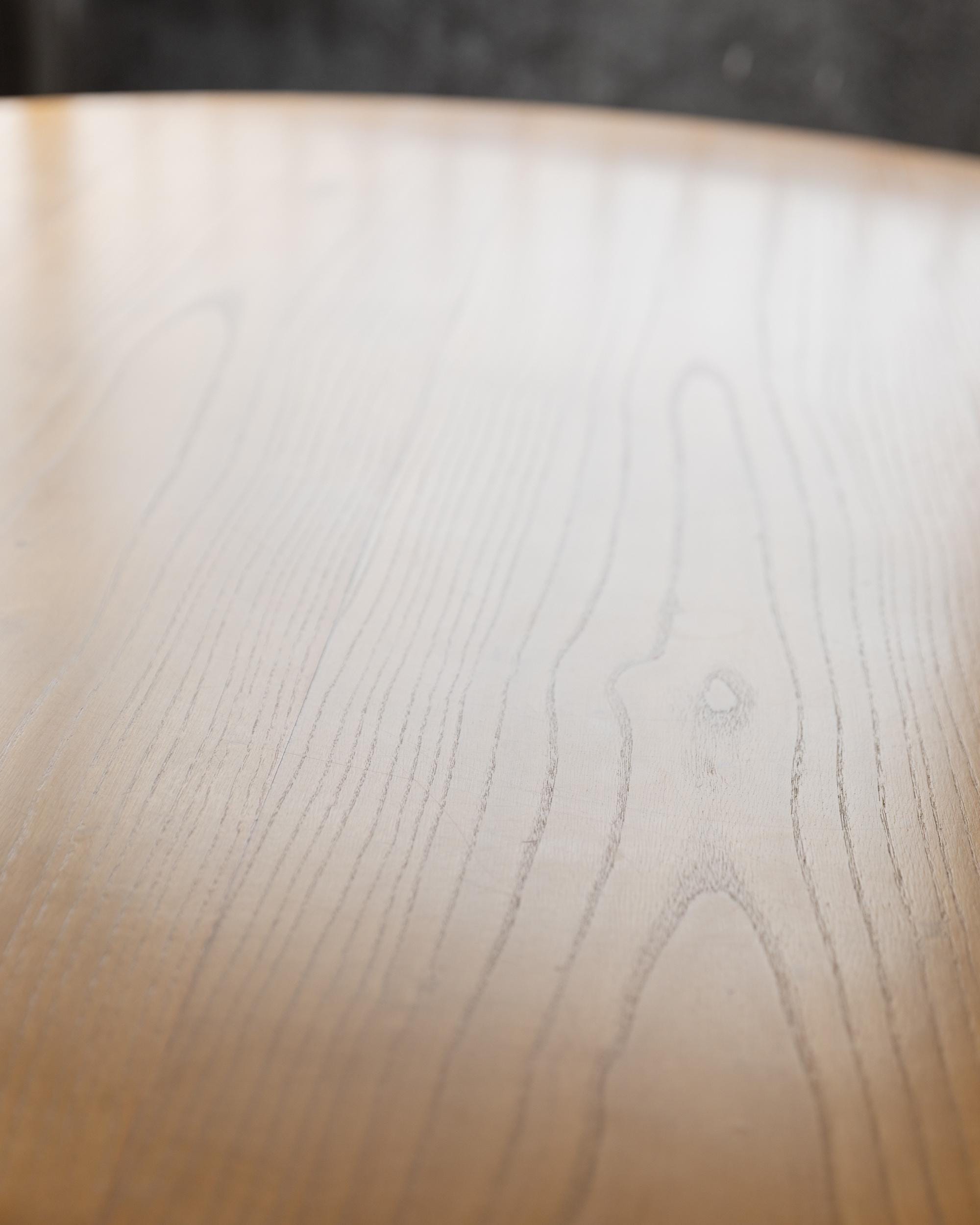 1980s Large Round Wooden Table — close-up of light wood surface