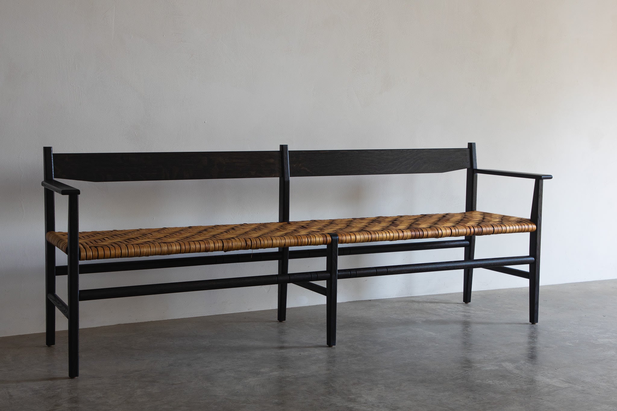 Silo Bench — side angle showing woven seat and black frame