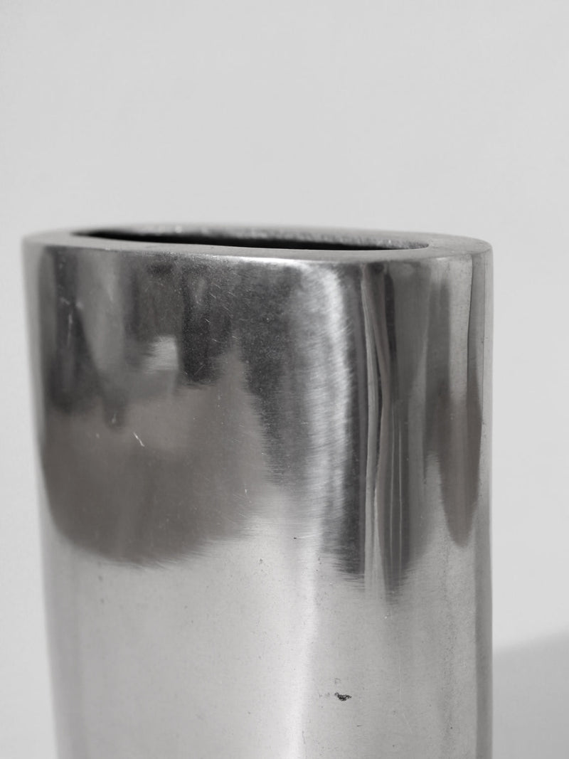 A close-up of the Polished Aluminum Square Flat Vase by Vintage Stories, showcasing its smooth, reflective surface and shiny finish, set against a plain light gray background for a classic 1960s-inspired look.
