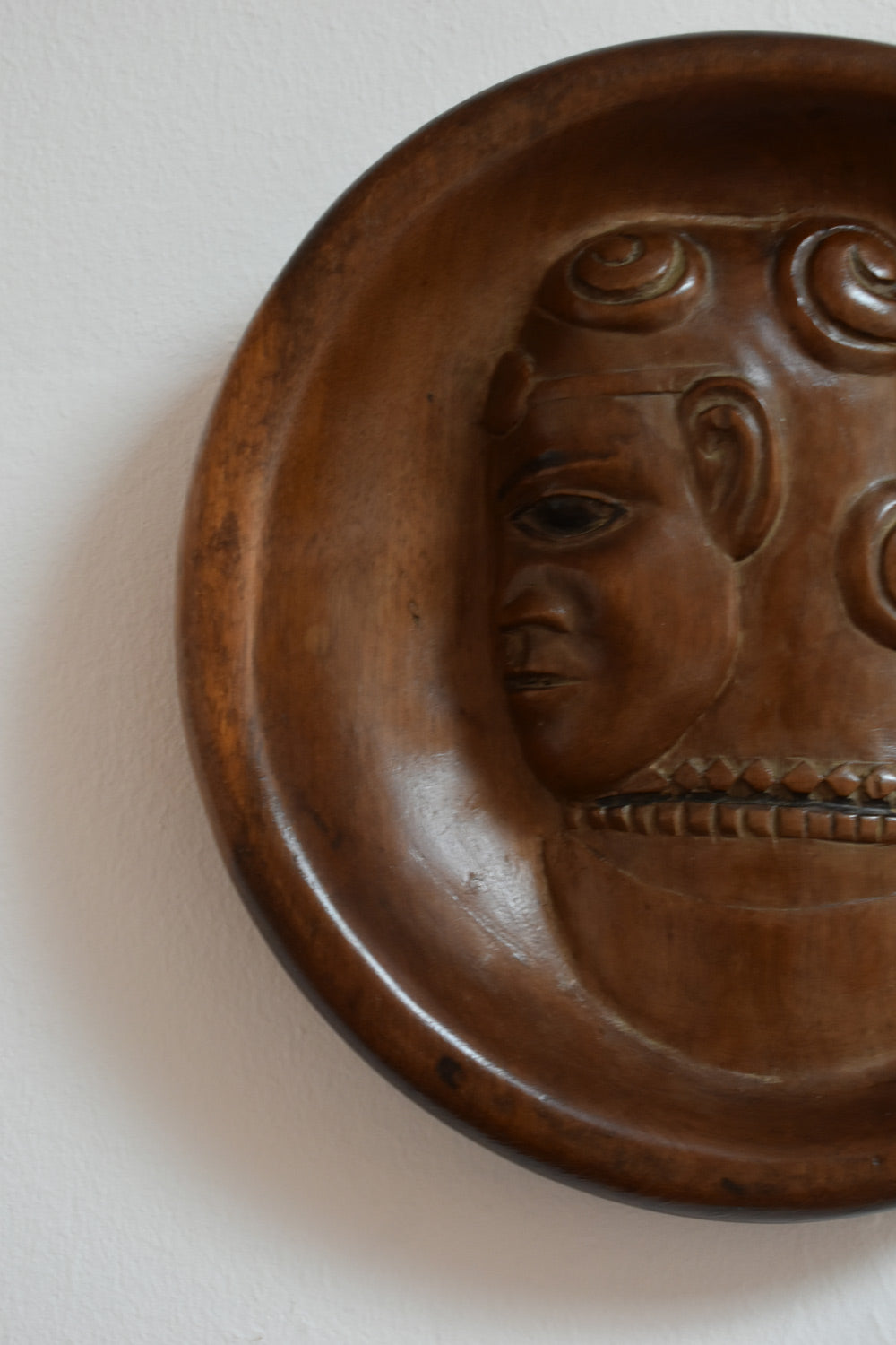 Africanist Low Relief Round Wooden Wall Sculpture — top view of carved wooden face detail
