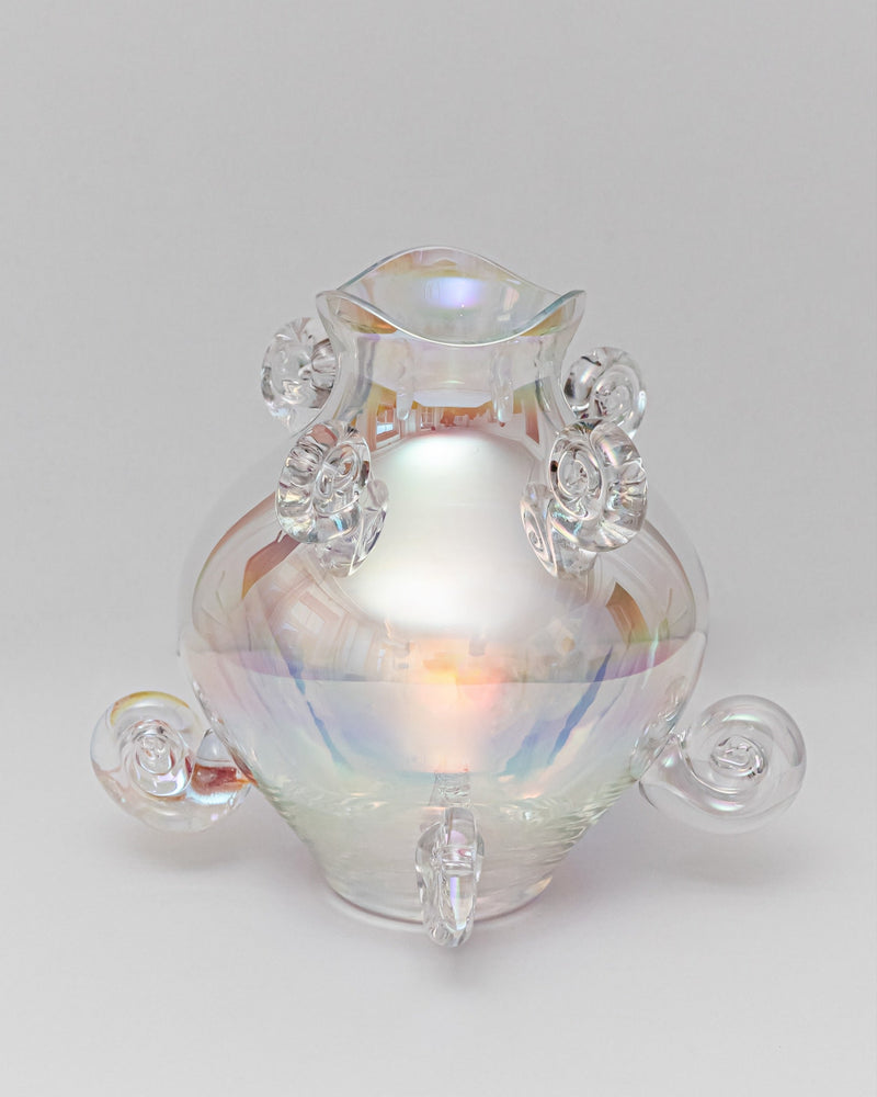 Iridescent crystal vase with curved handles and rainbow reflections