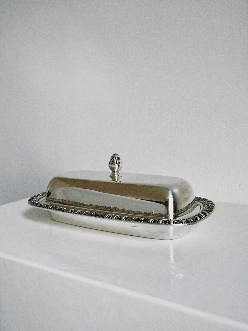 Silver butter dish with ornate decorative rim and domed lid