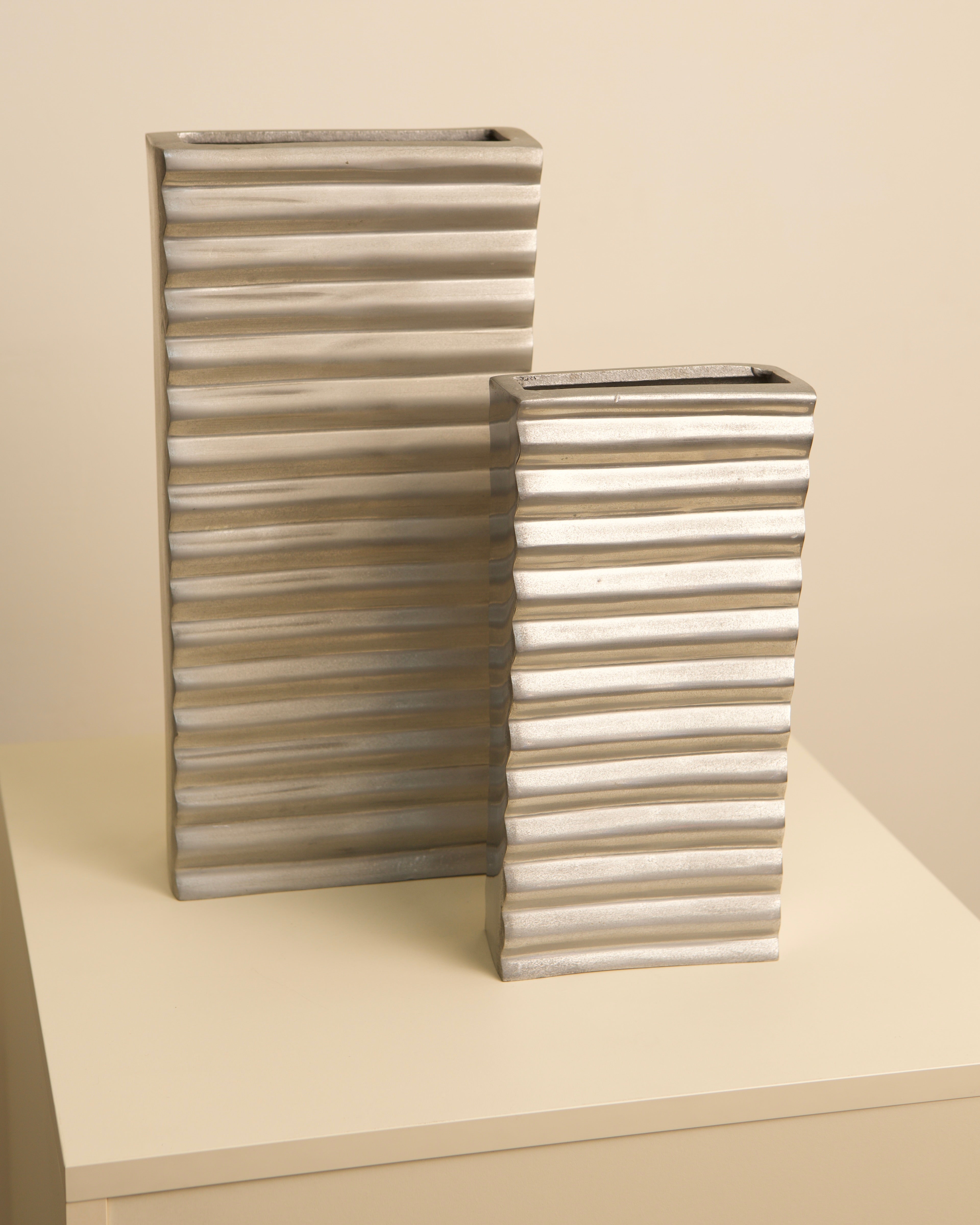 Pair of ribbed aluminum Italian vases with corrugated texture