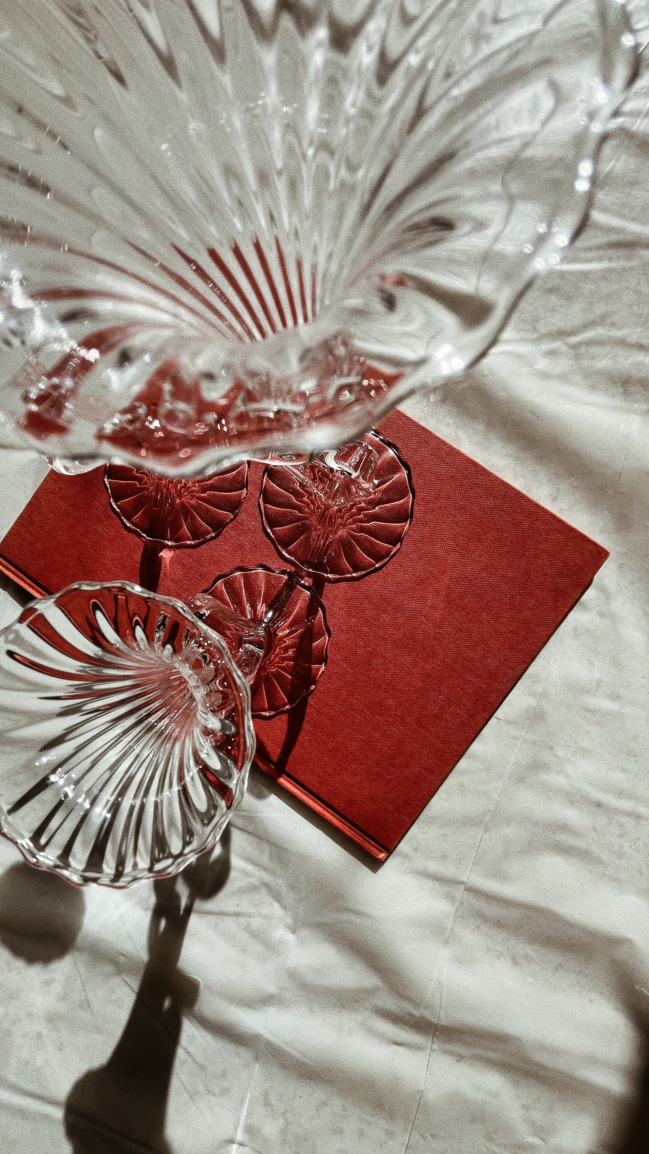 Crystal glass ribbon candleholder with radial pattern on red book
