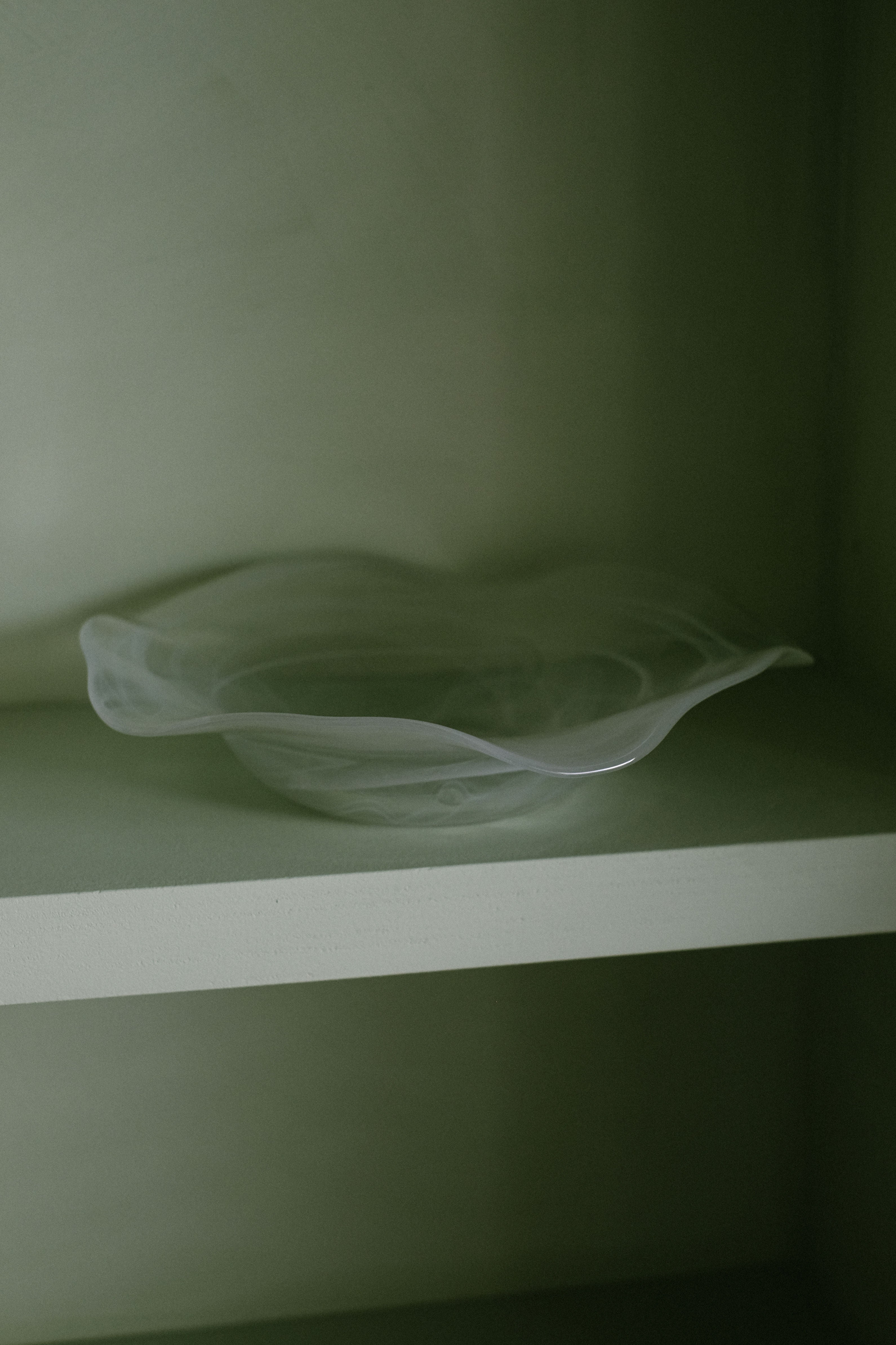 Swirl Glass Bowl — placed on light green shelf