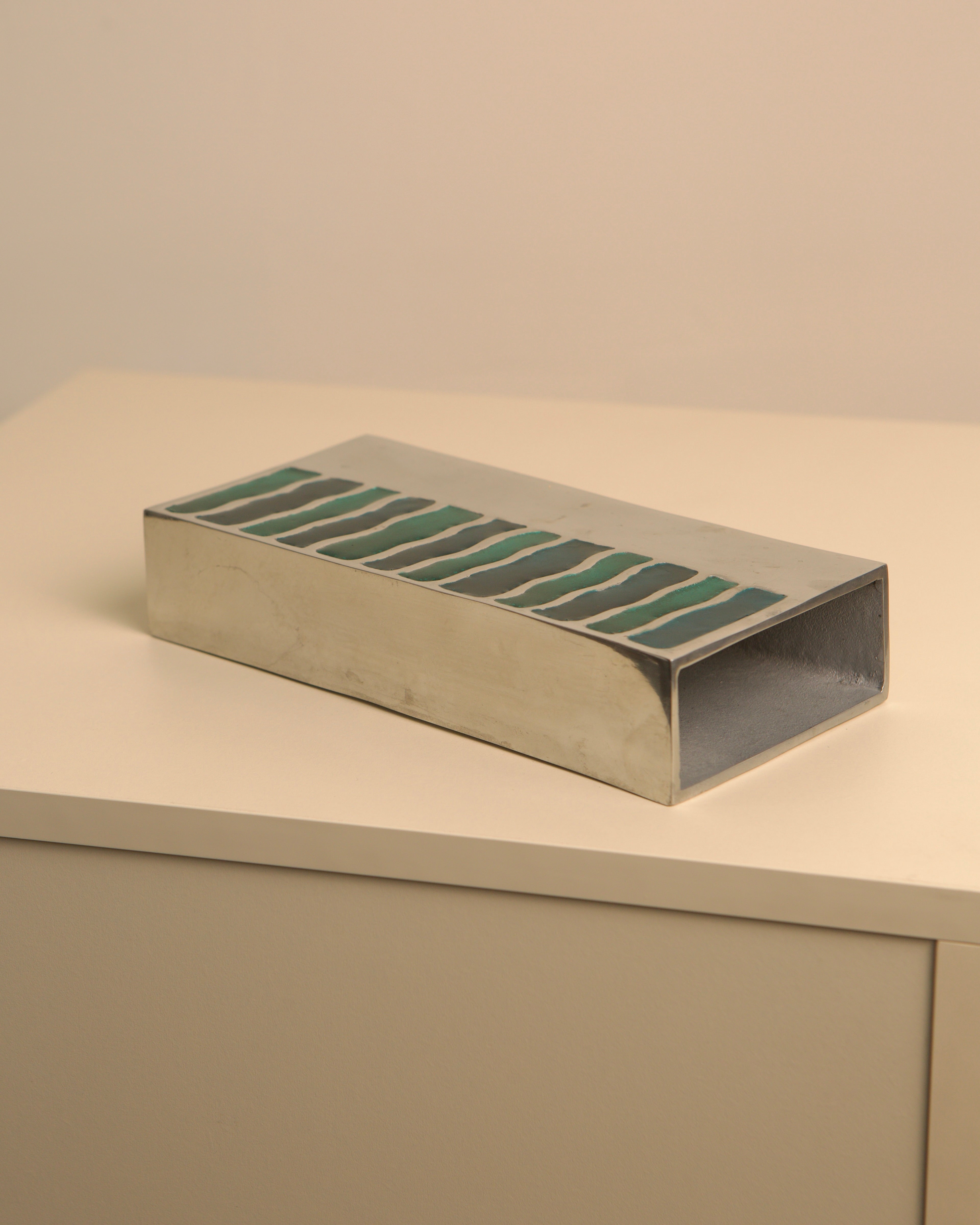 Green enameled aluminum vase detail showing striped pattern design
