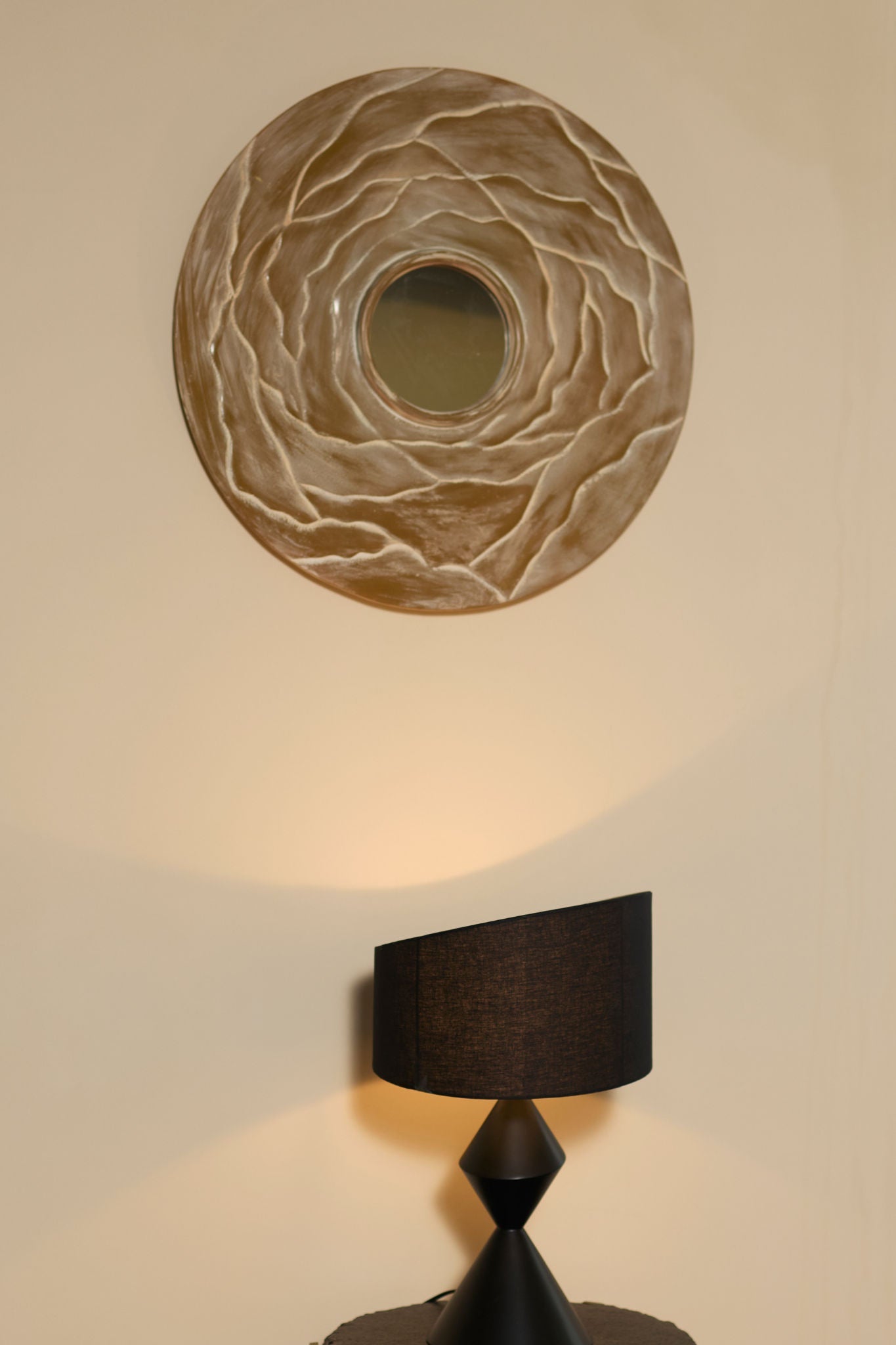 Orb' Aluminum Mirror — mounted above black lamp on side table