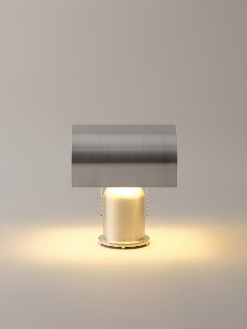 Modern cylindrical table lamp with brass base and gray metal shade