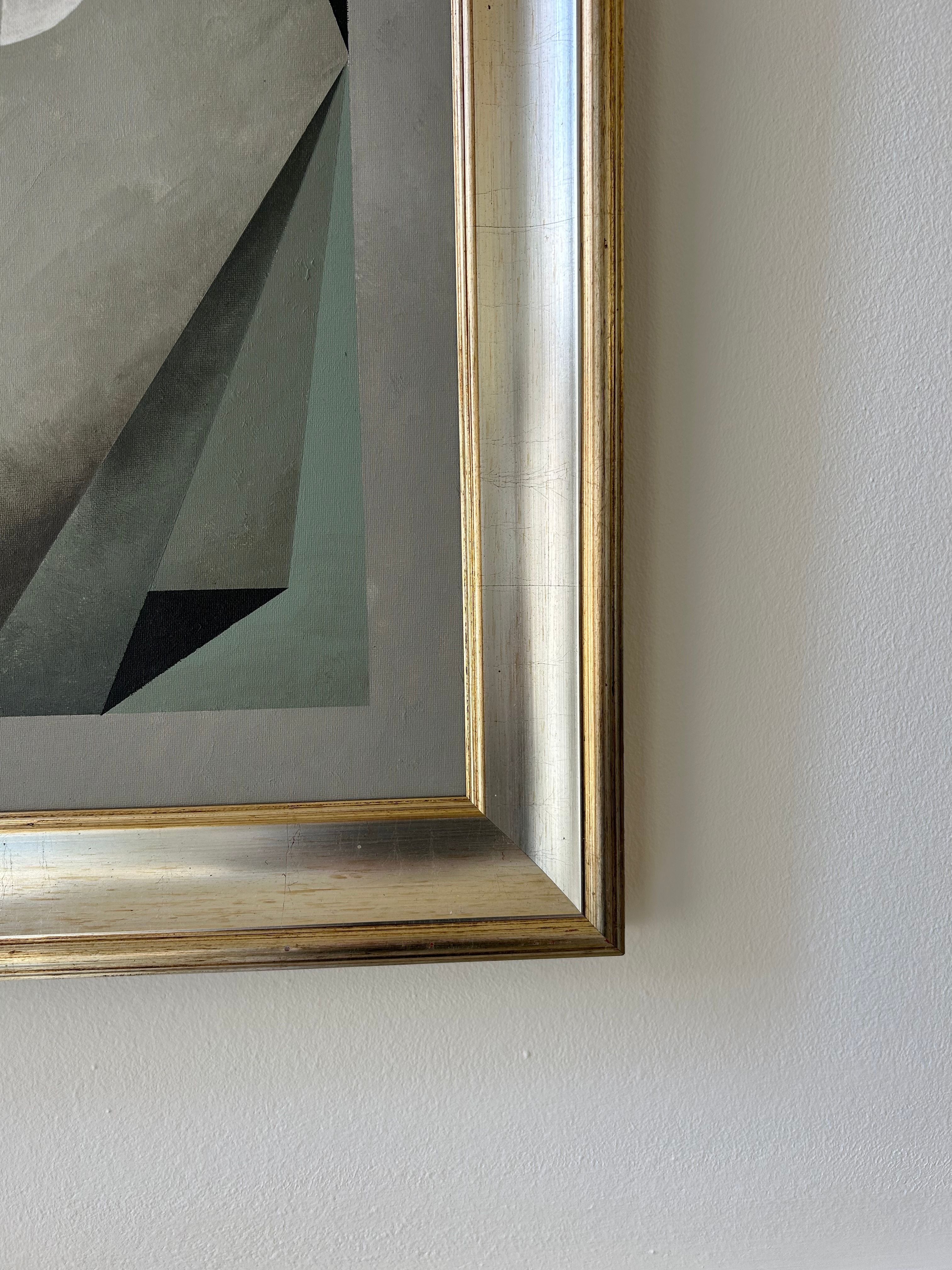 A close-up of the "Nest" painting by Iris Bavelaar shows the bottom right corner of this contemporary linen wall art, featuring abstract geometric shapes in muted forest green tones against a plain light wall.