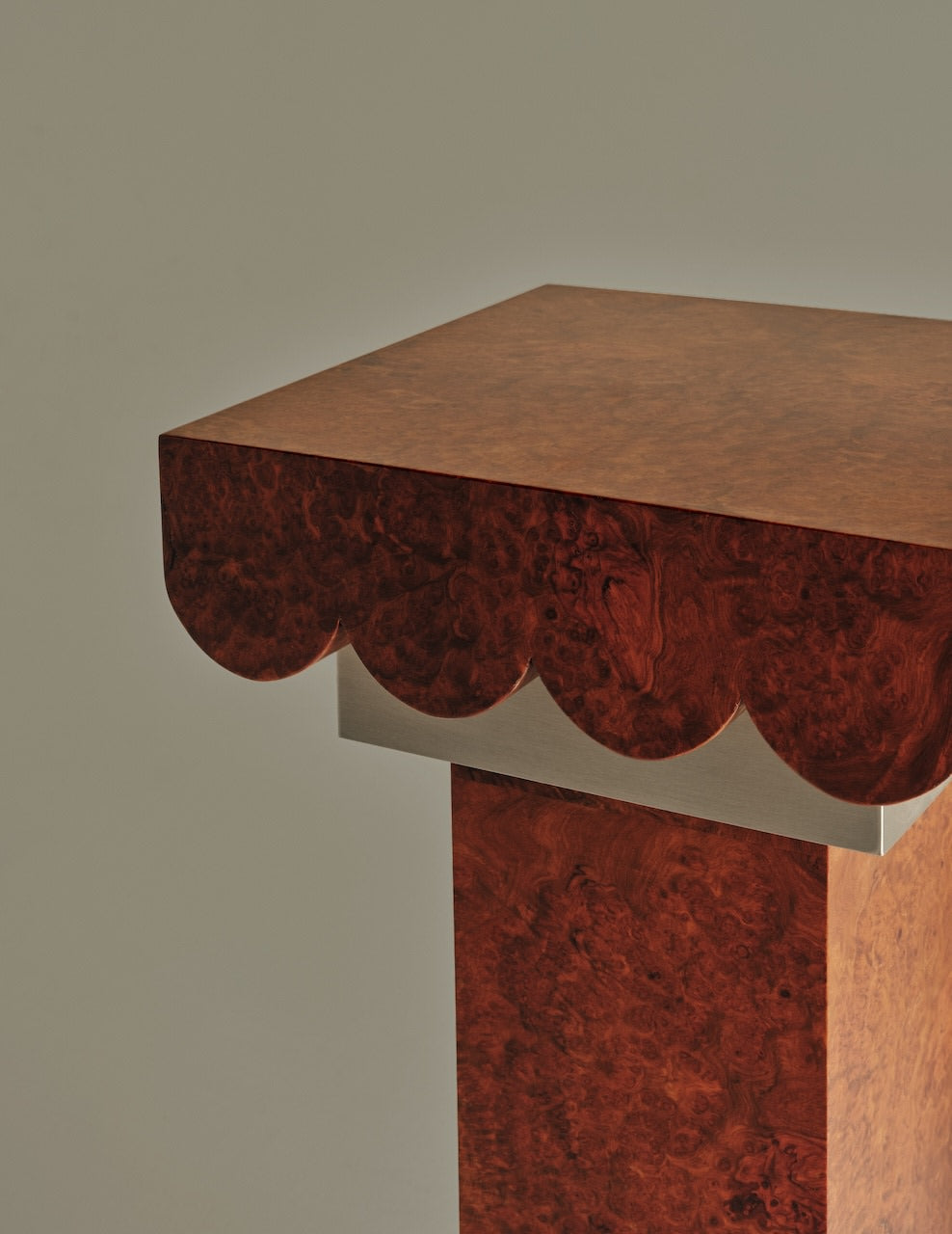 Dione Pedestal — side angle of rich wood finish with scalloped edge