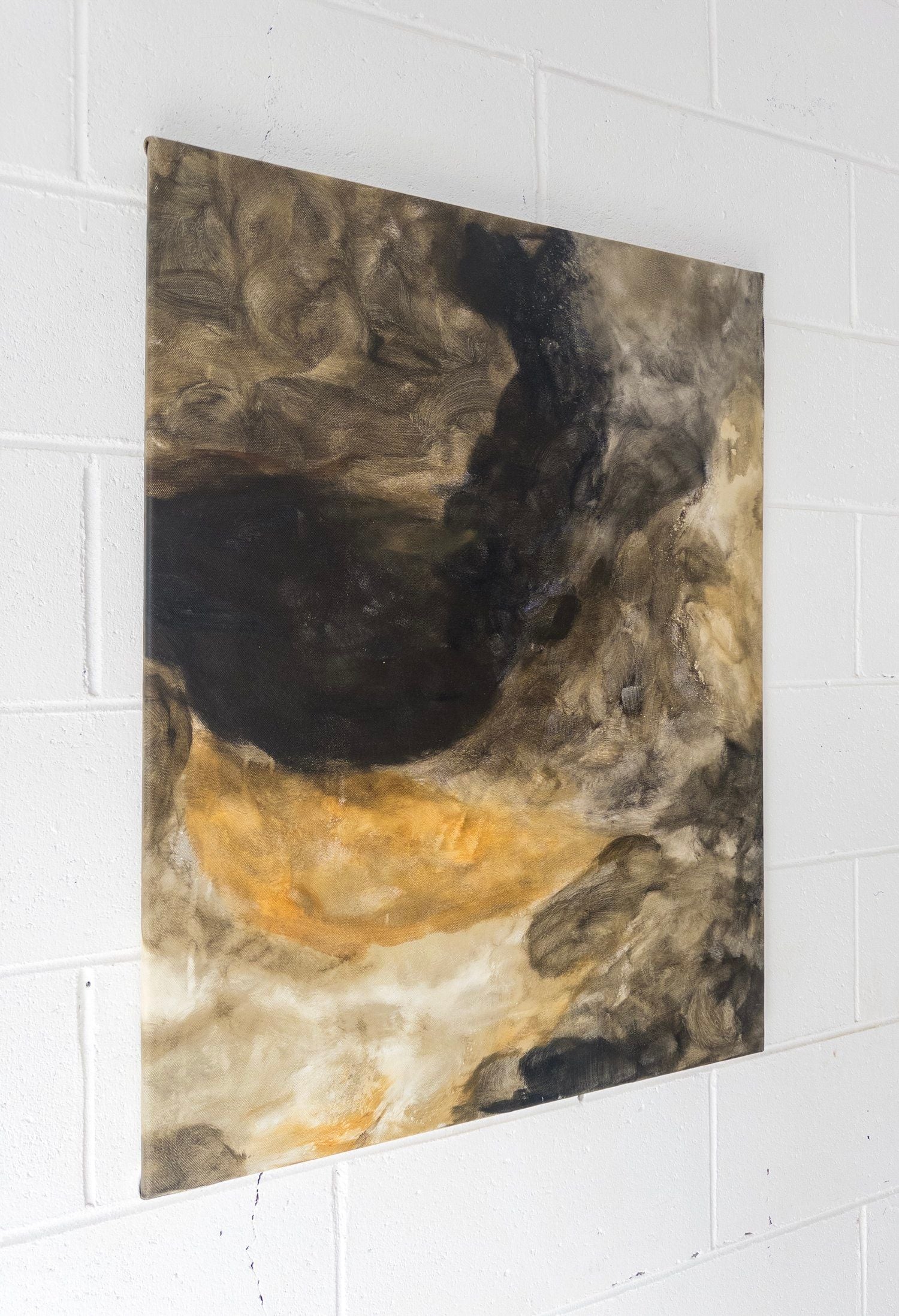 “Bodies Entwined I” by Natasha France is an original, square mixed media artwork on canvas featuring swirling brown, black, gold, and cream tones with a smoky, cloud-like look. It hangs elegantly on a white textured wall.