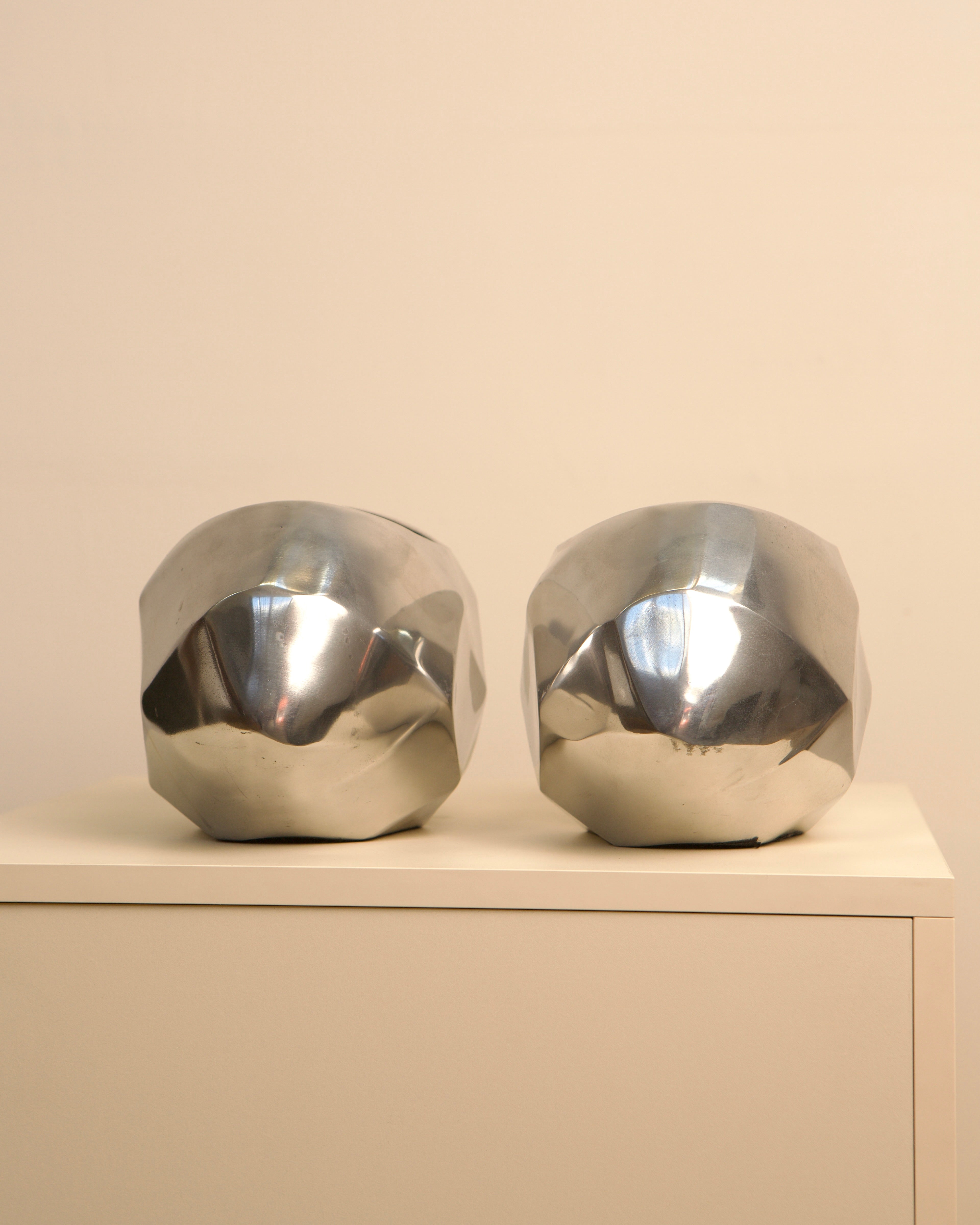 Pair of Italian aluminum capsule vases on neutral surface