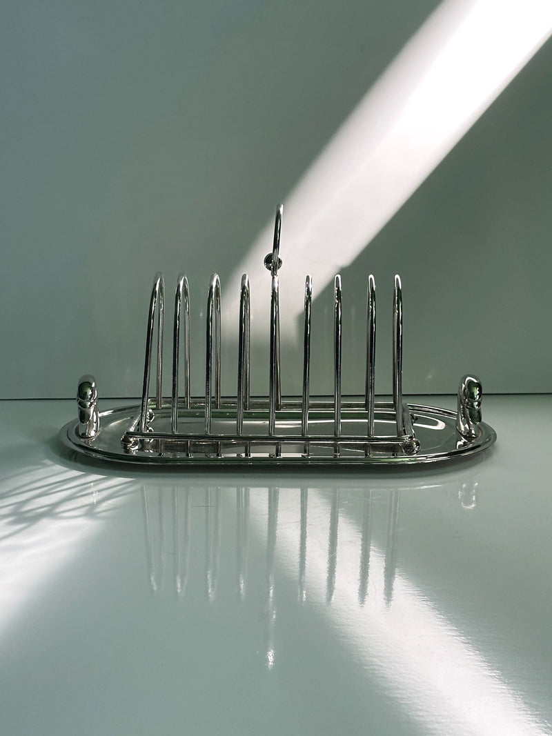Chrome-plated toast rack with vertical slots on oval tray