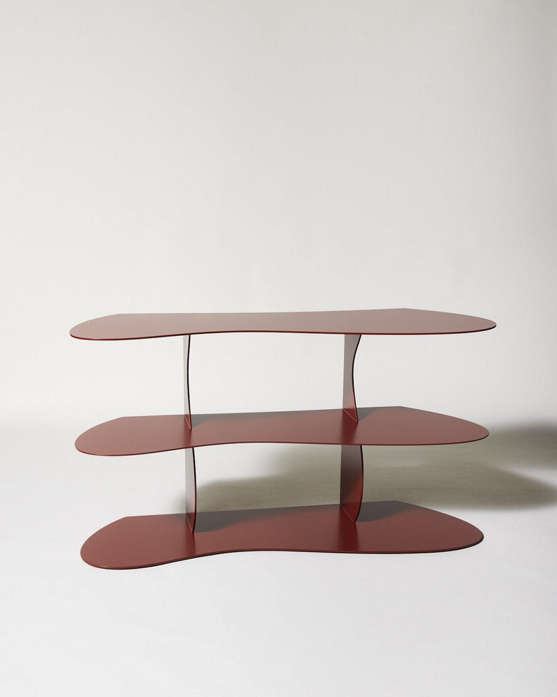 Red metal multi-tier oval shelf with curved supports by Nicole Lawrence
