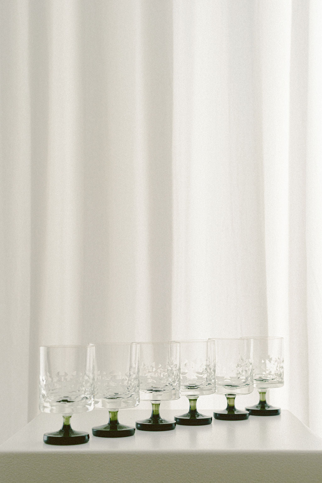 Vintage Ingrid Wine Glasses — arranged on white pedestal with soft backdrop