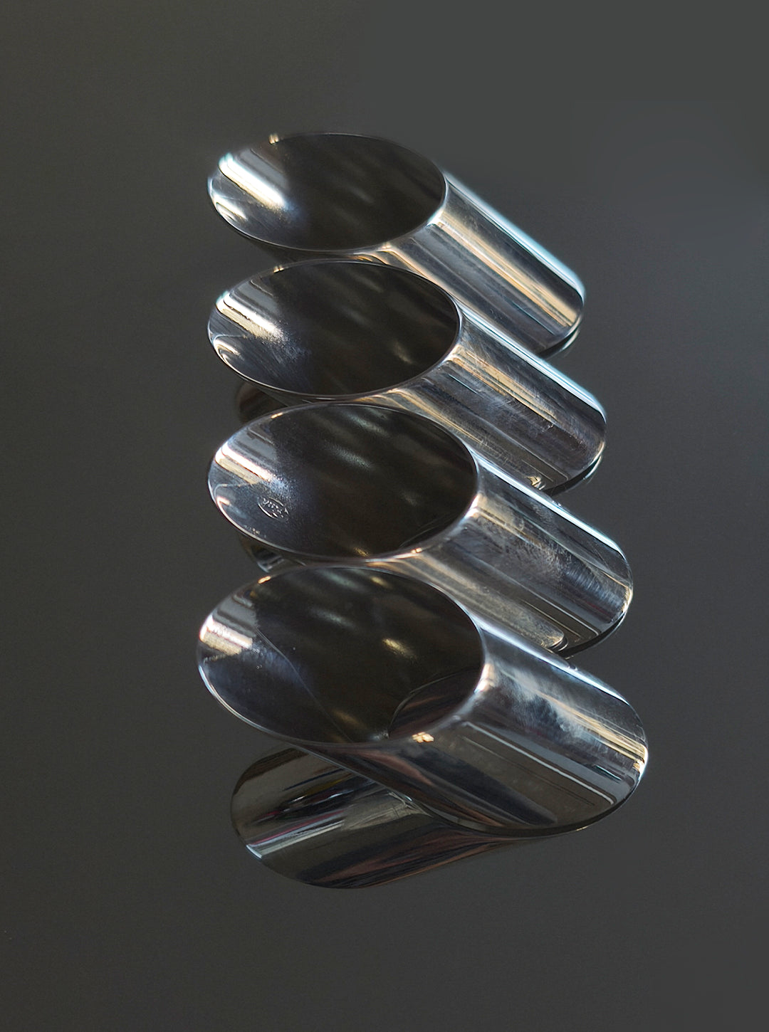 Set of 4 Silver-plated Napkin Rings — angled view on reflective surface