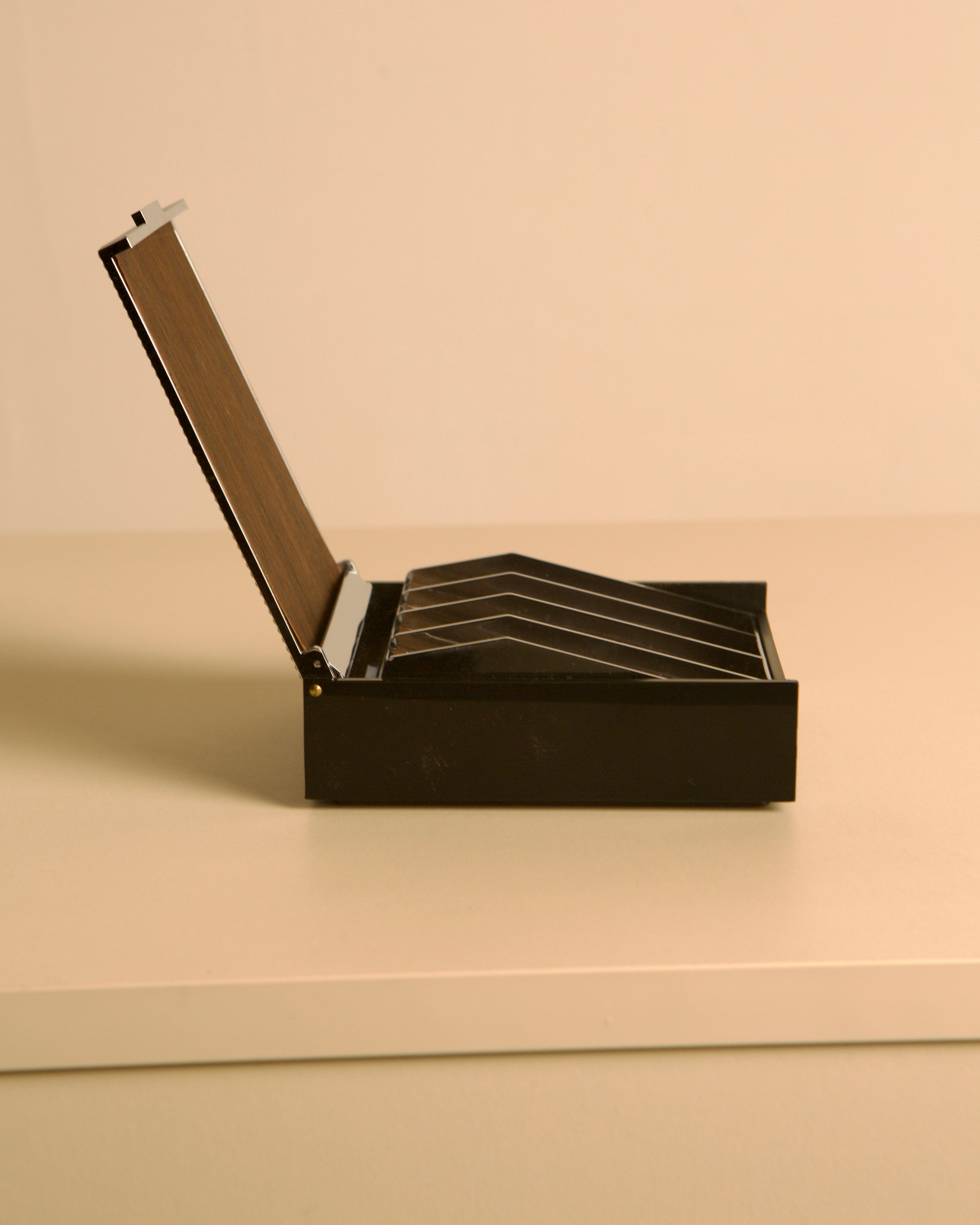 Italian box made of metal and wood, 80s — side view on neutral surface