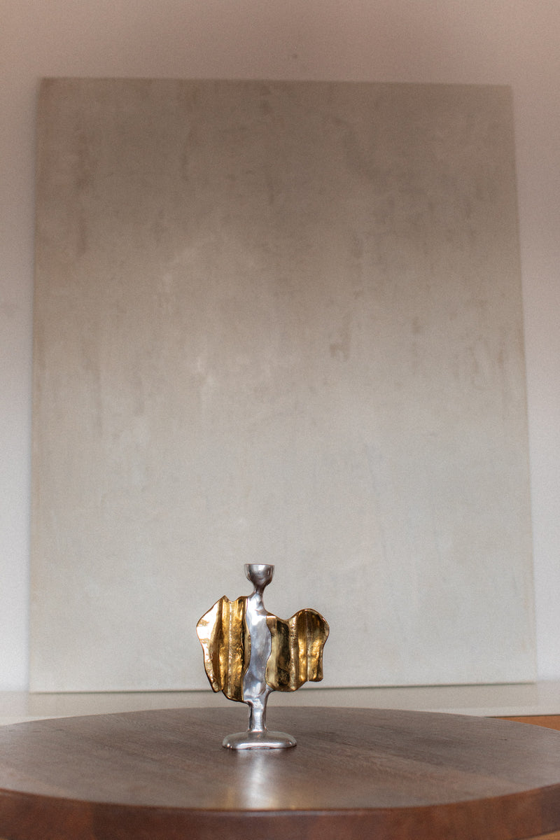 Modern sculptural candleholder with golden brass wings detail