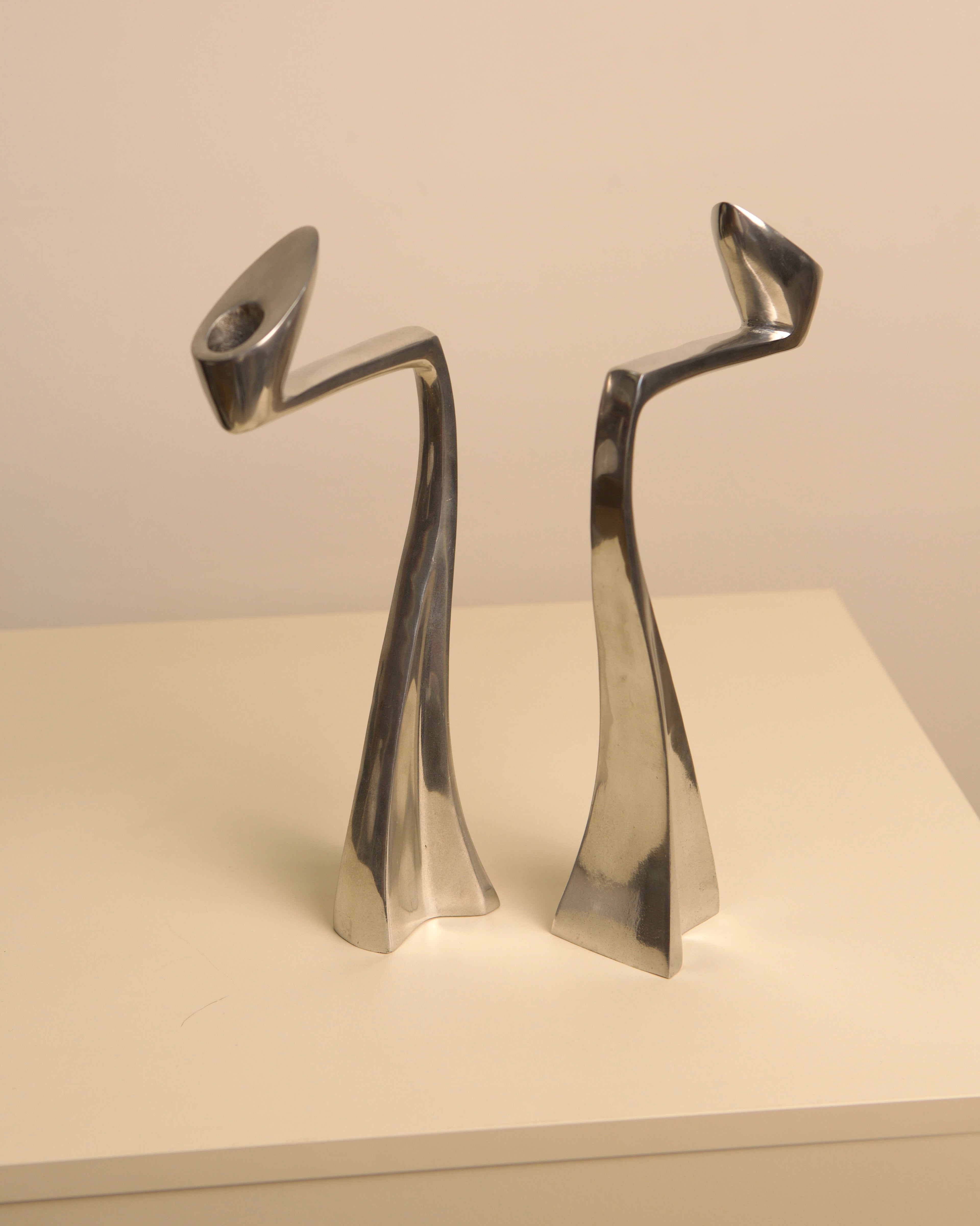 Paire de bougeoirs "Swan" par Matthew Hilton 80's — side angle showing polished metal finish
