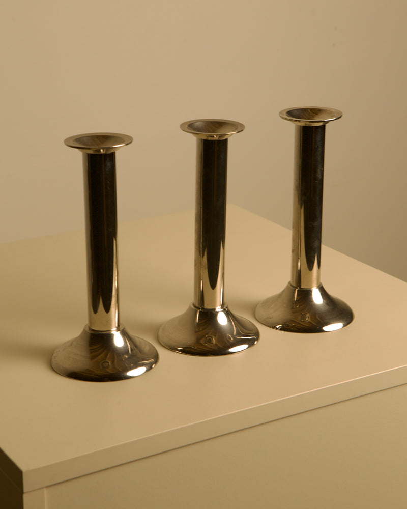 Set of 3 Italian Silver-plated Metal Candlesticks from the 70s — close-up of shiny metal surface on white table
