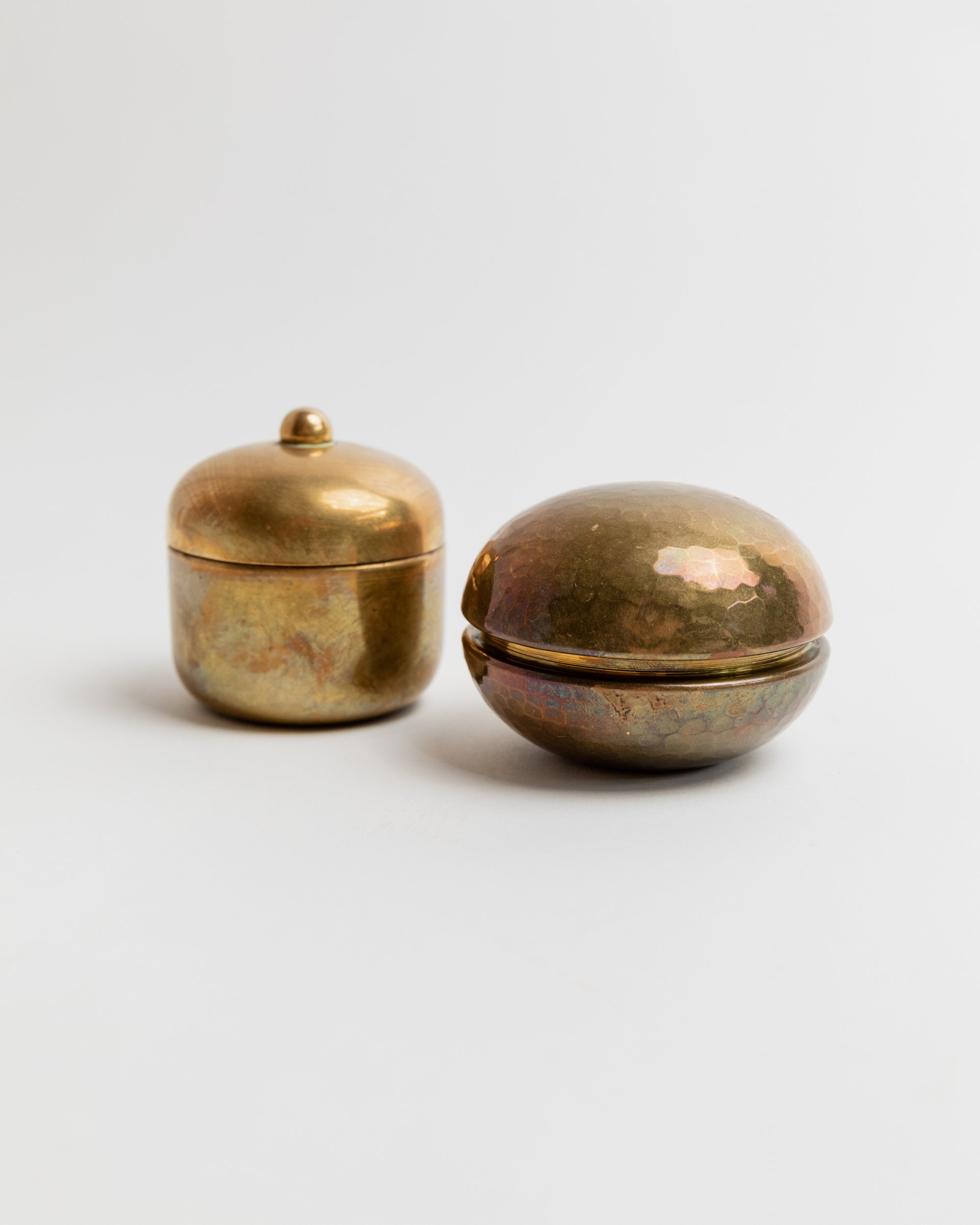 Vintage brass tins with weathered patina on neutral background