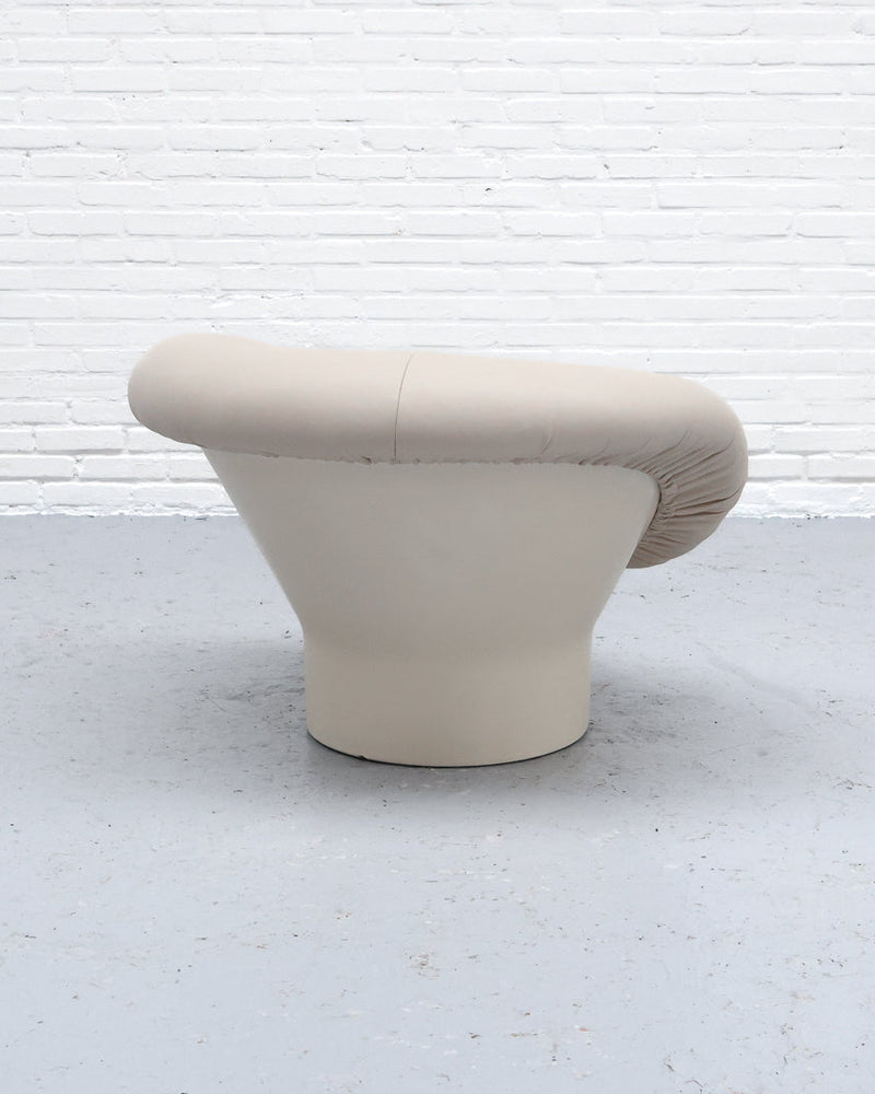 Beige upholstered Krokus armchair profile view showing curved design