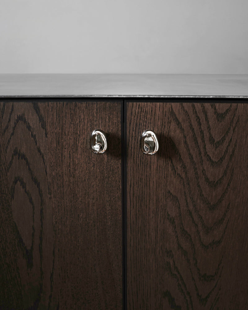 Rud Knob - Titanium — close-up of titanium knob on dark wood cabinet