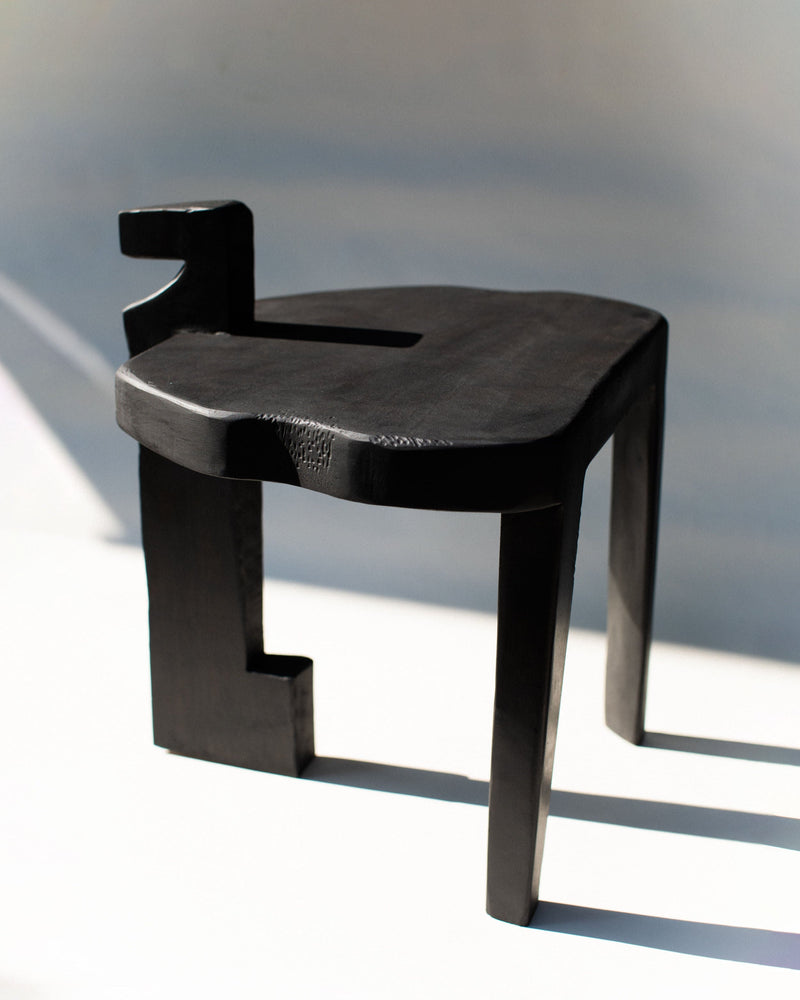 Black wooden Sharie stool with geometric cutout design detail