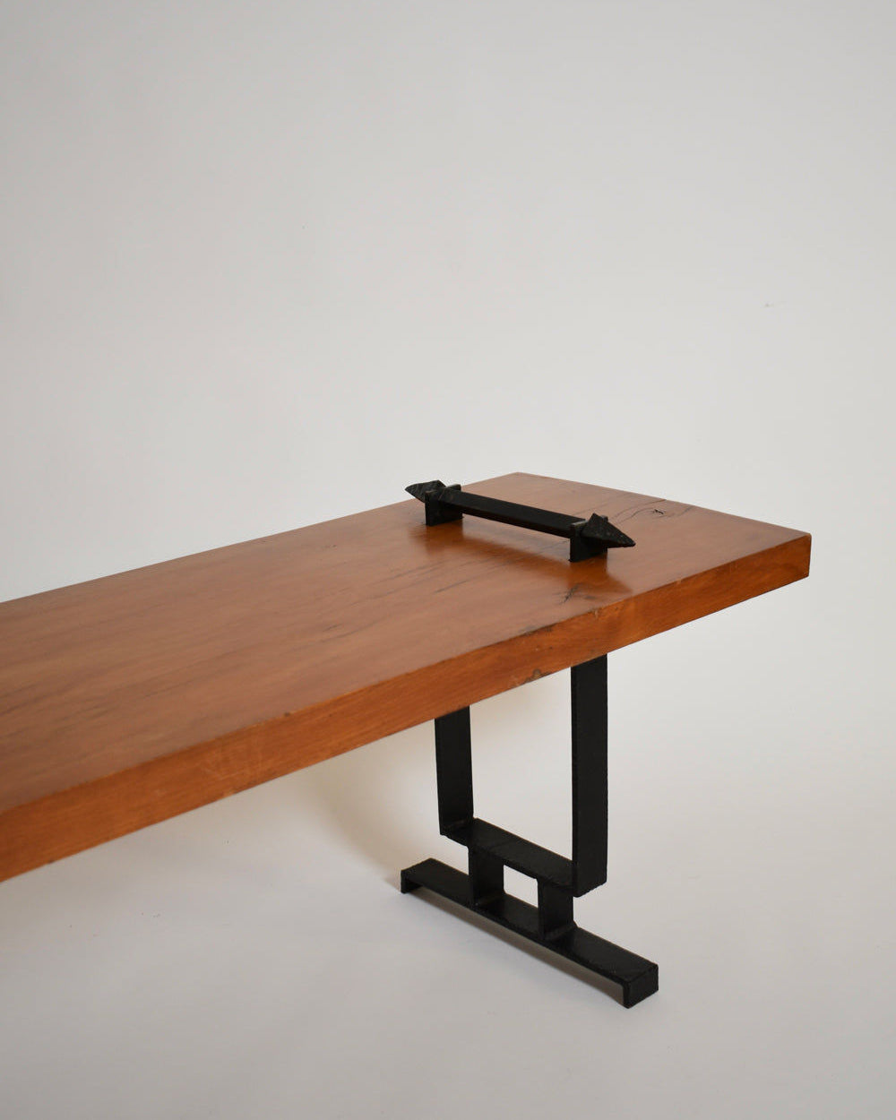 The Barracuda Interiors Wrought Iron and Natural Wood Coffee Table, 1950s, features a thick rectangular wooden top, black metal legs, and a minimalist handle-like detail on one end, shown against a plain white background.