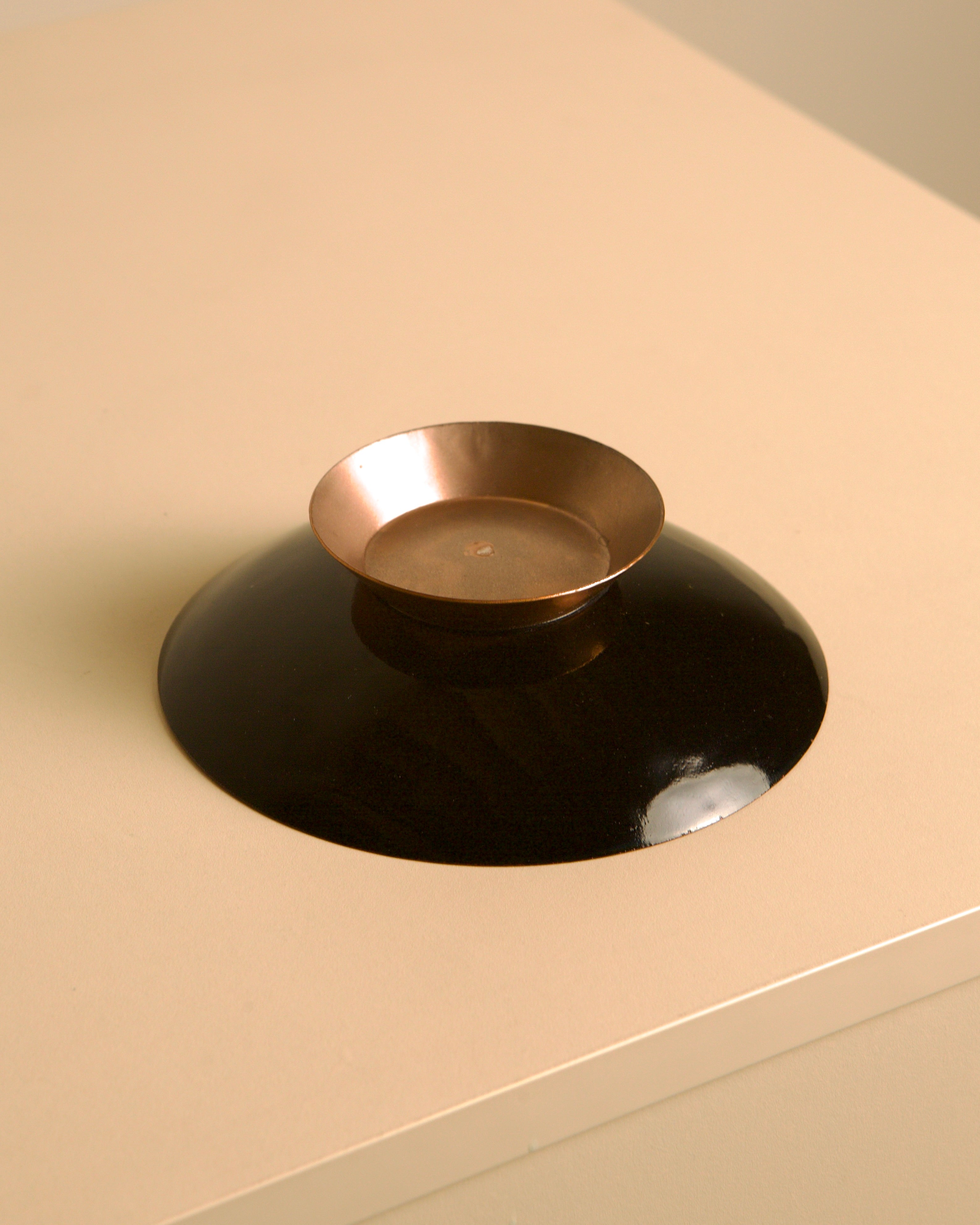 Circular Italian lacquered trinket tray with a copper base, 80s — angled view on neutral surface