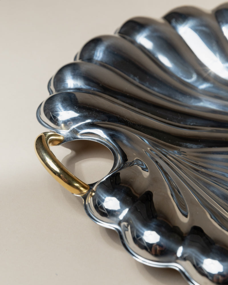 Curved stainless steel serving tray detail showing sculptural ridges