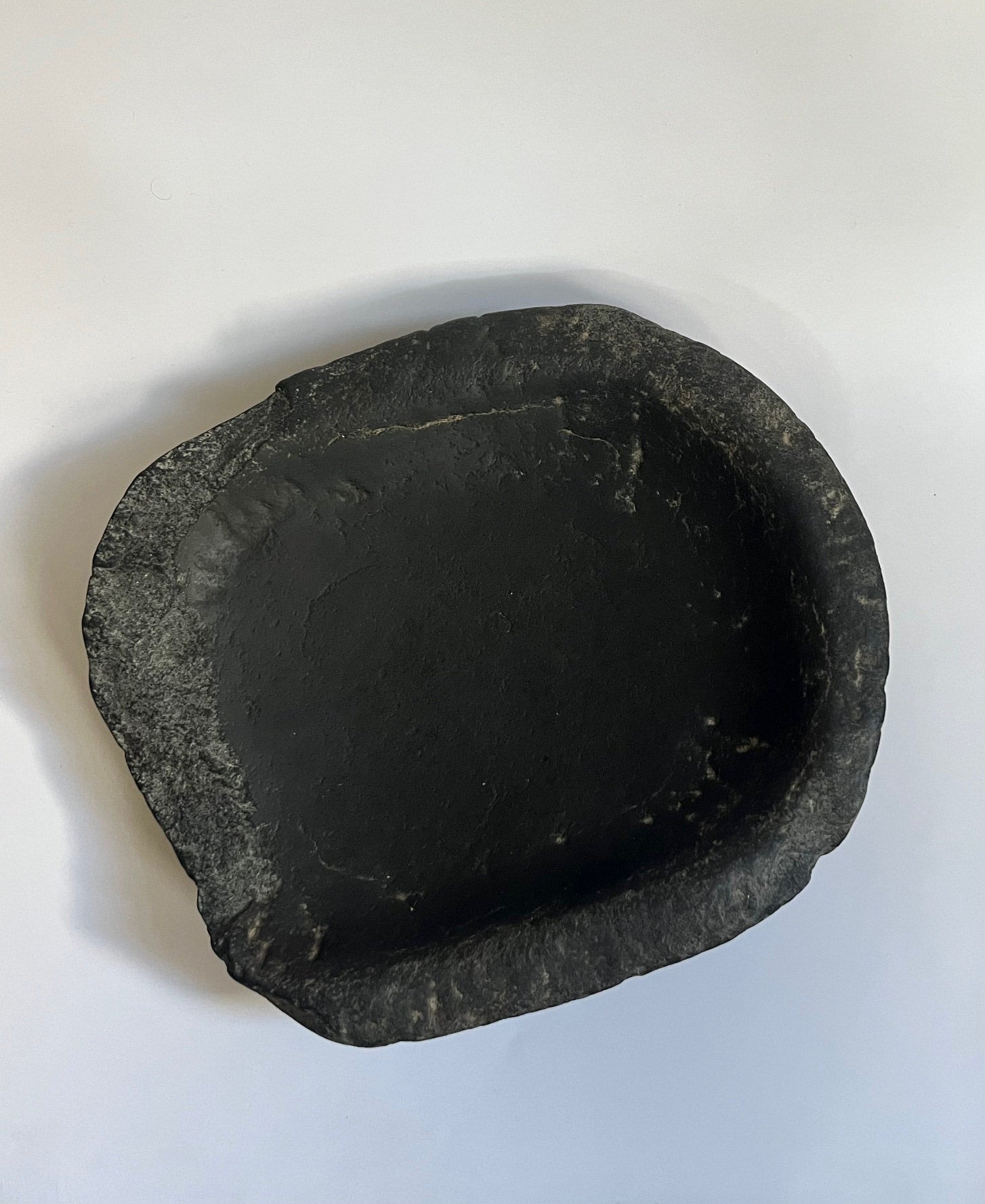 Interior view of antique black stone bowl showing natural texture