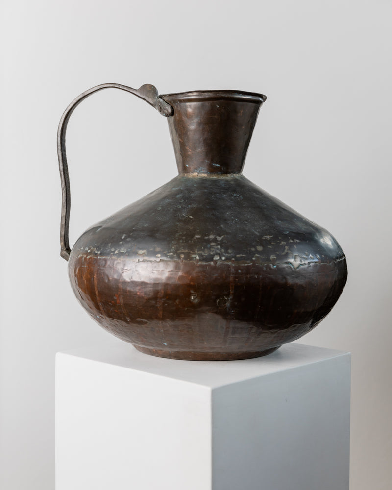 Antique copper bronze jug profile view showing patina details