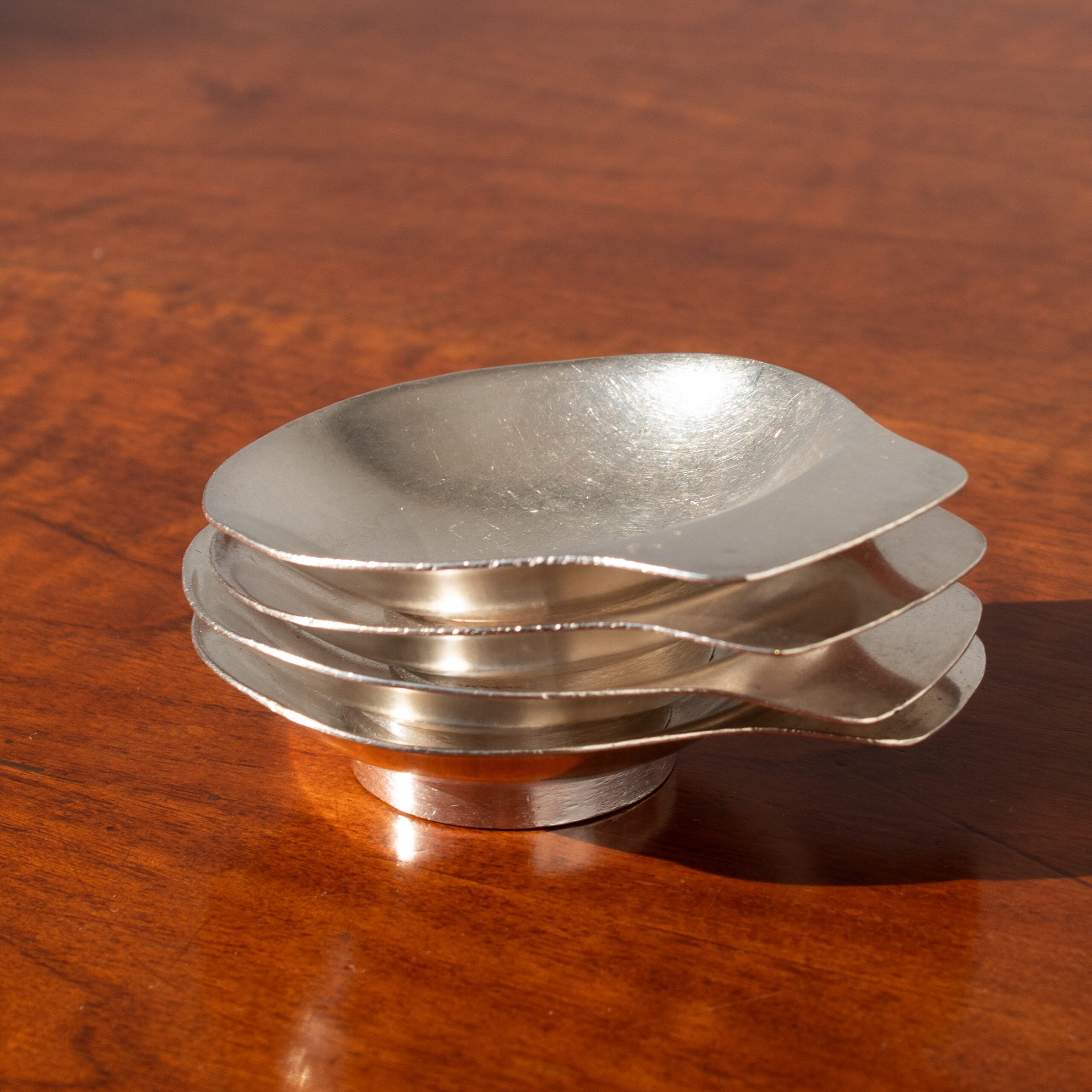 Arthur Krupp Dessert Plates in Metal — stacked view on wooden table