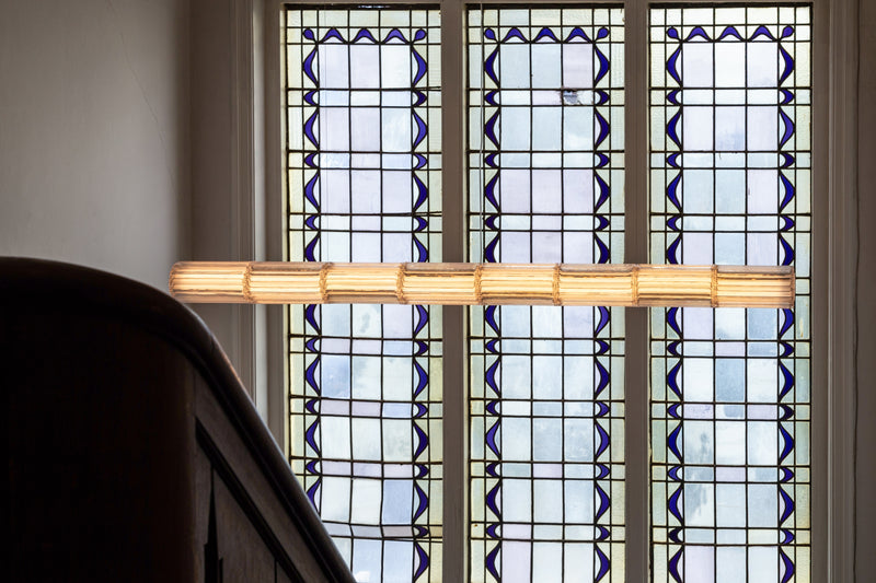 Former" Aperture 200 — close-up of pendant light against stained glass windows