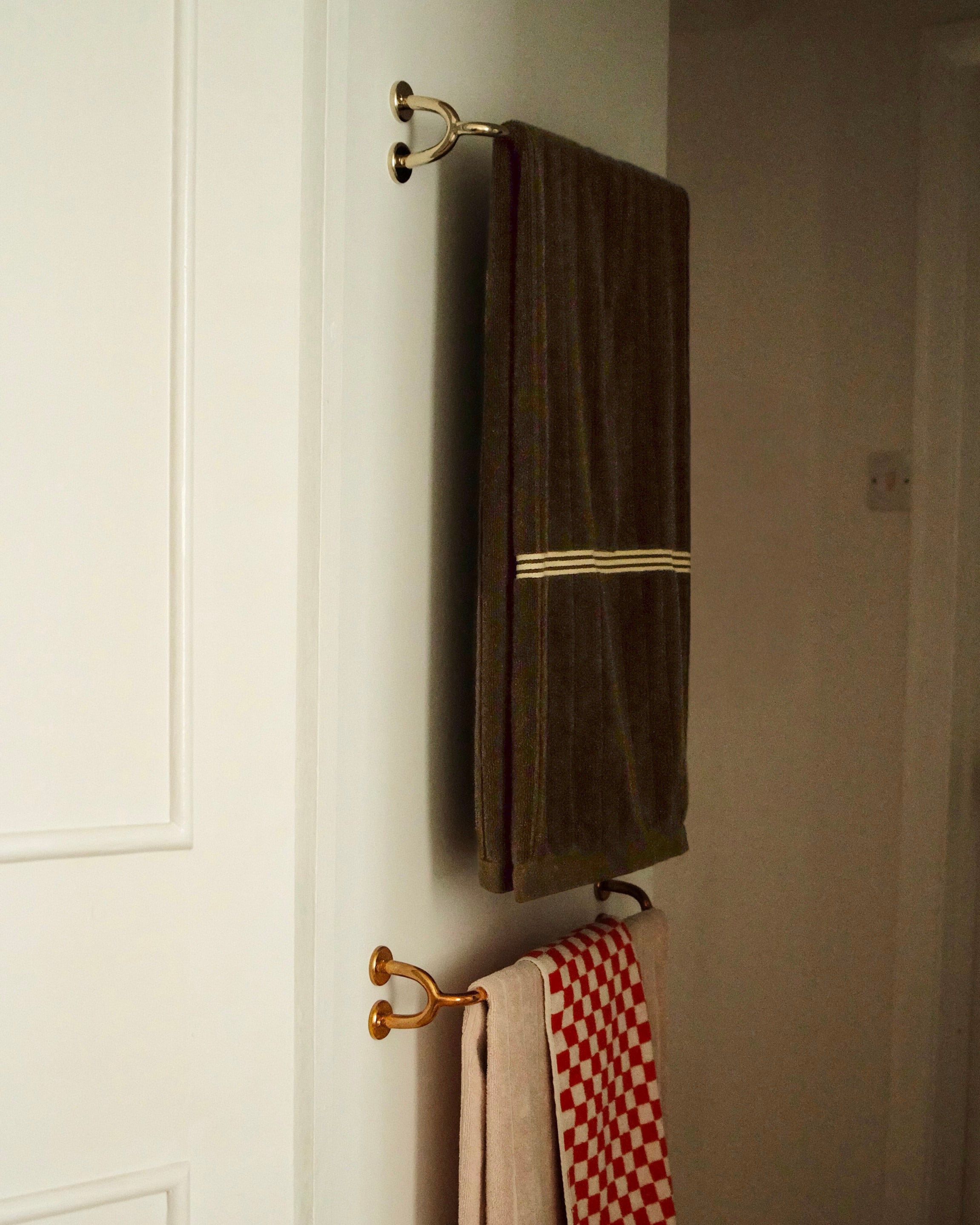 FAUNA Towel Bar (2 sizes) — mounted on white door with towels
