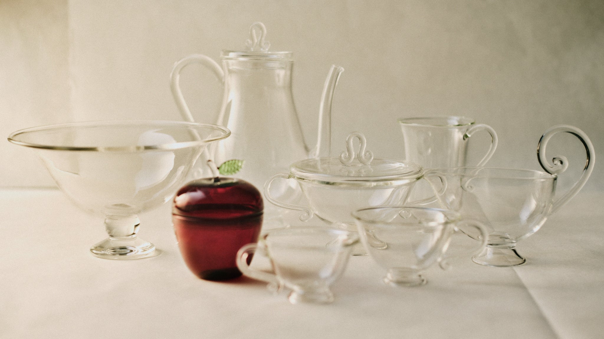 La Pomme — side angle of glass fruit bowl with red apple