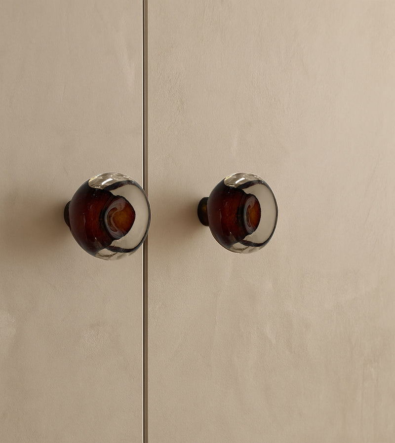 Knob Collection Sculptures in Glass — close-up of amber glass knobs on cabinet