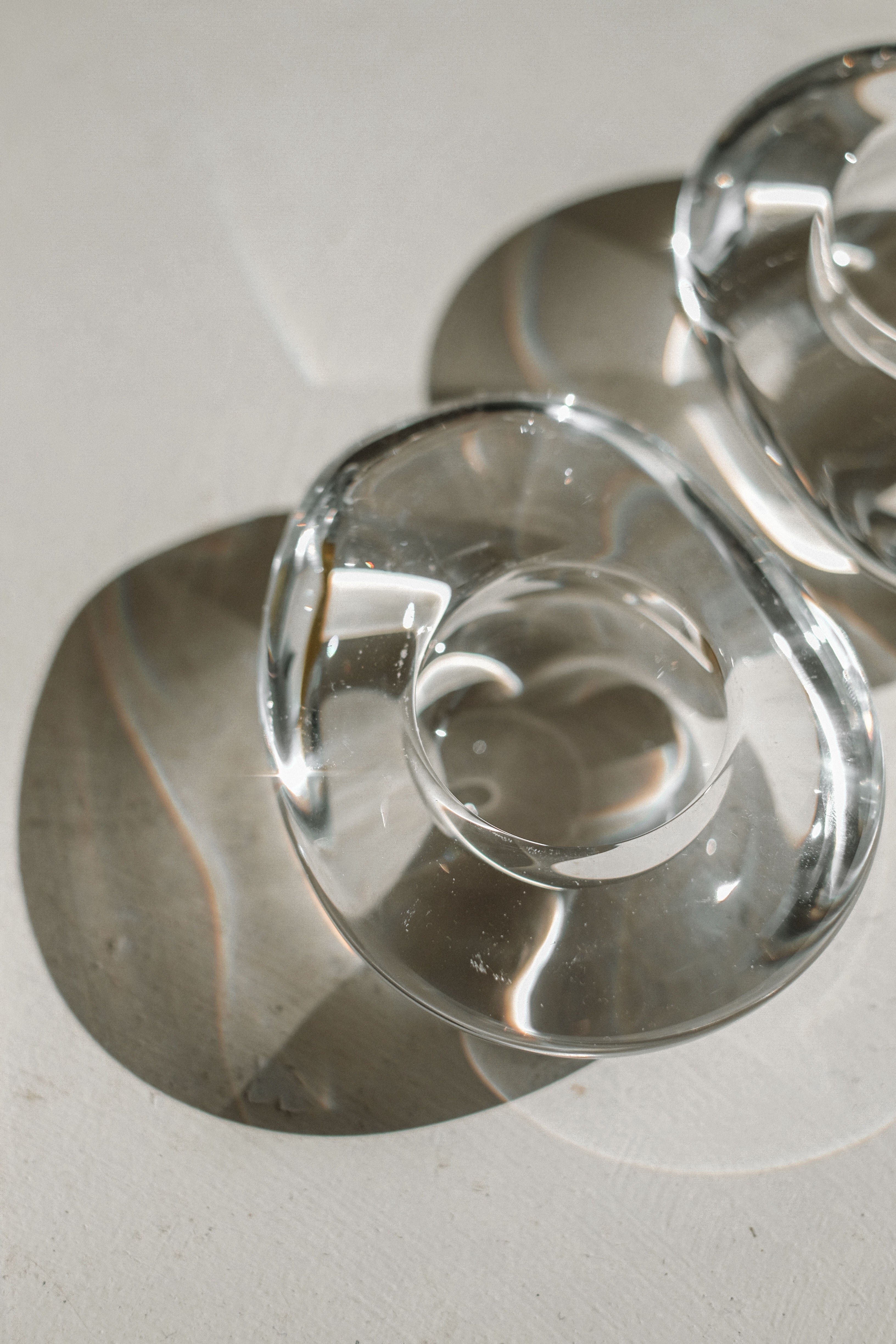 Crystal candleholders showing curved glass design and light reflections