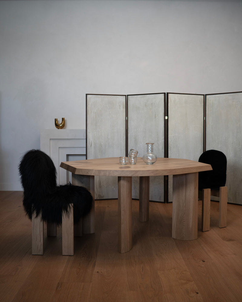 Gilbert Edge Dining Table - Oak — close-up of oak table with black chairs