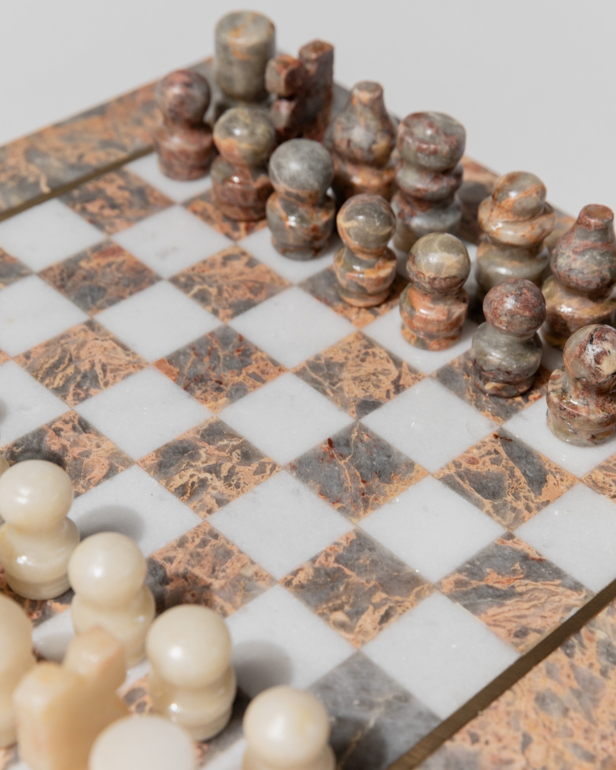 Vintage marble chess set with ornate pieces on checkered board